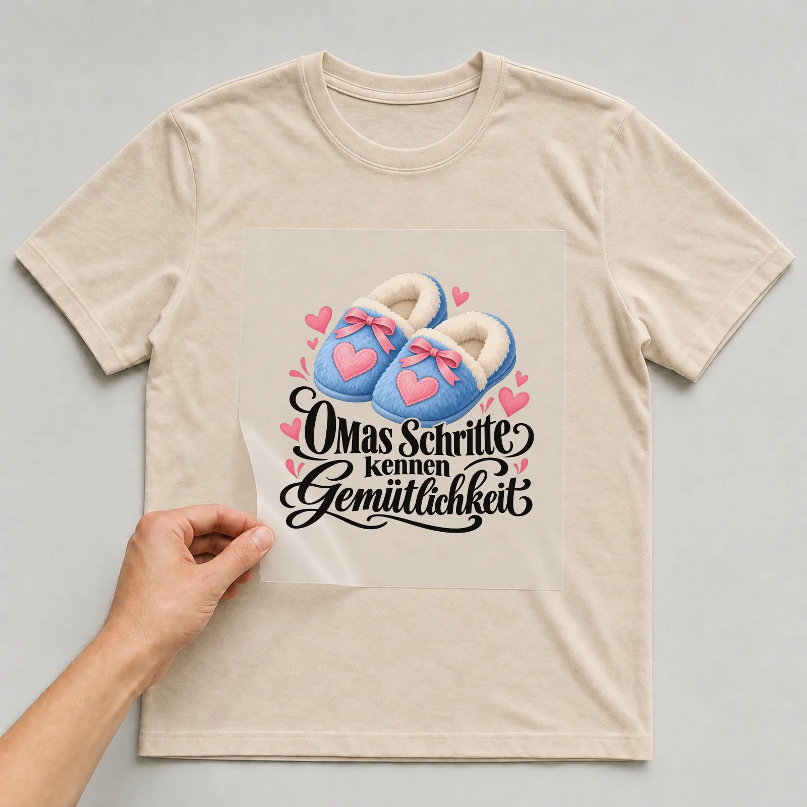 Bügelbild „Omas Schritte kennen Gemütlichkeit“ auf beigem T-Shirt, Folie wird aufgelegt