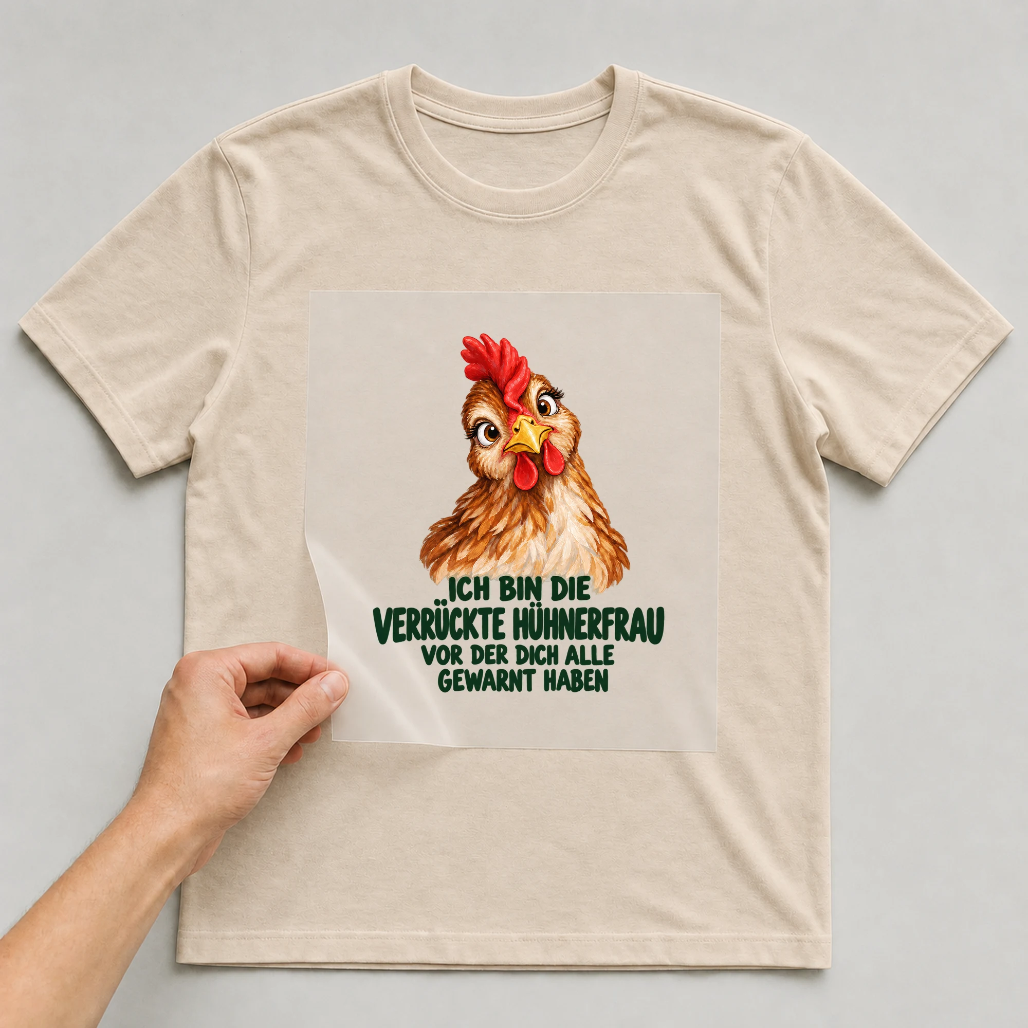 Bügelbild „Ich bin die verrückte Hühnerfrau vor der dich alle gewarnt haben“ auf beigem T-Shirt, Folie wird aufgelegt