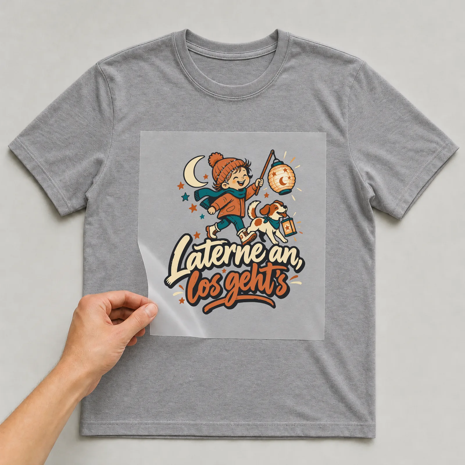 Bügelbild Laterne an, los geht’s auf grauem T-Shirt, Folie wird aufgelegt