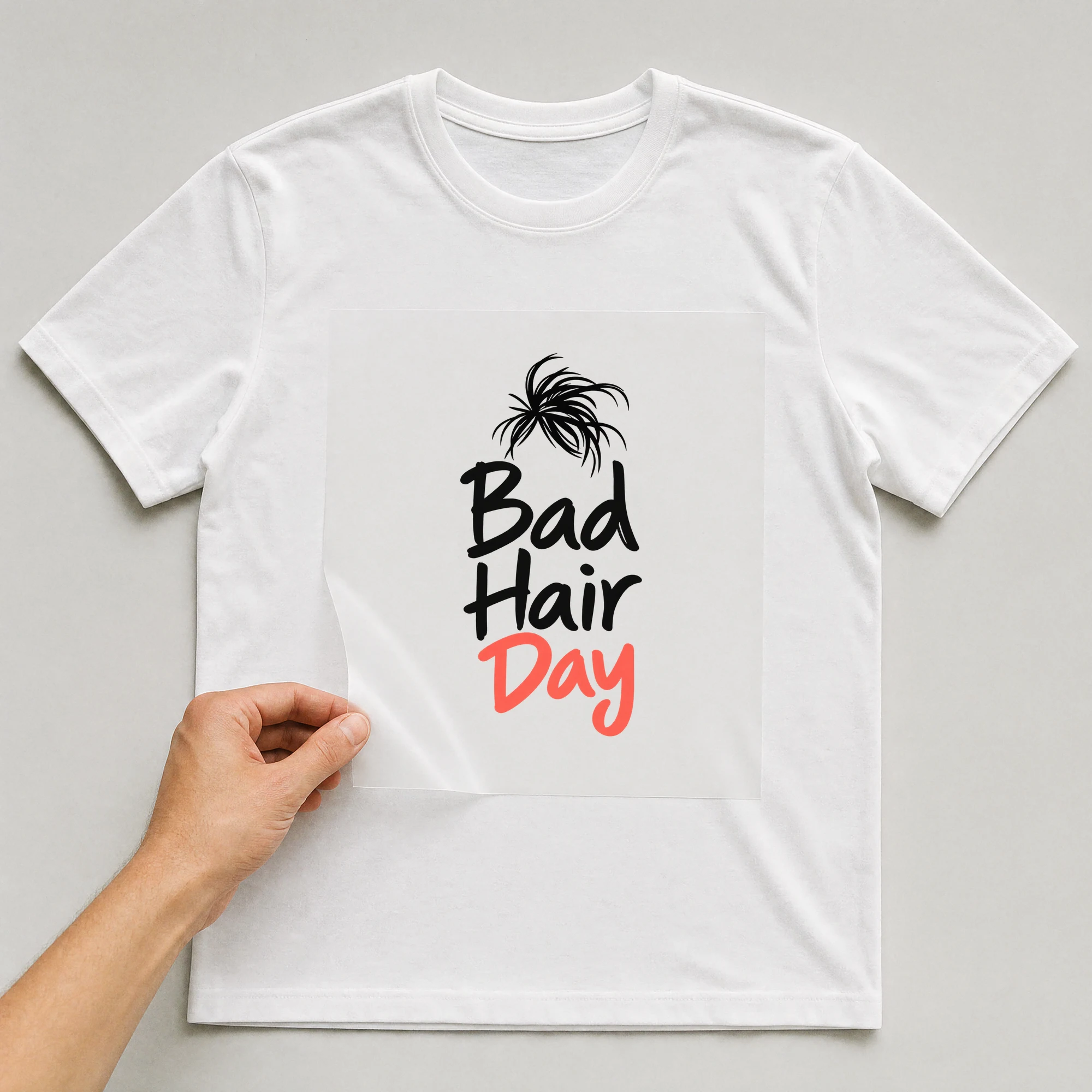Bügelbild „Bad Hair Day“ auf weißem T-Shirt, Folie wird aufgelegt