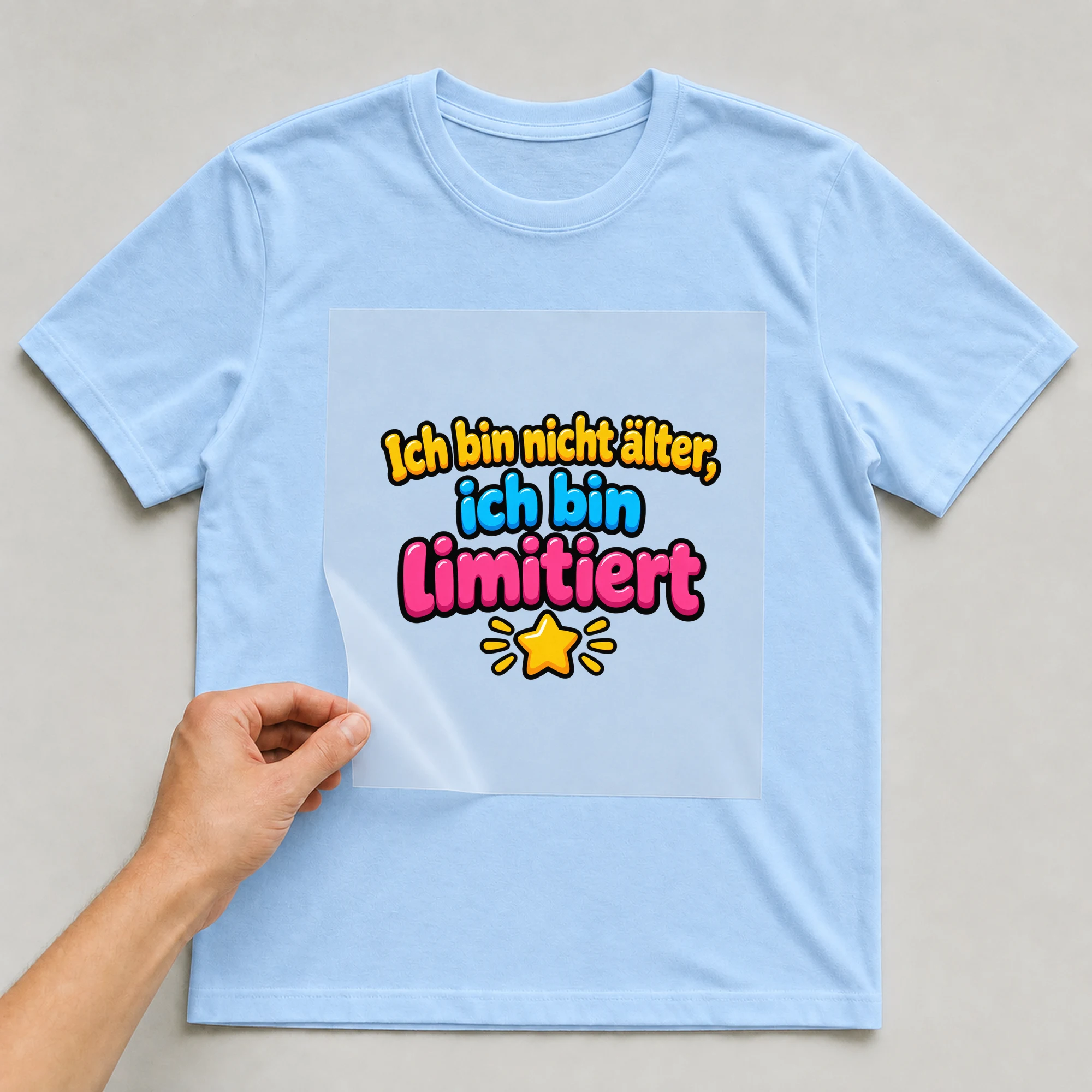 Bügelbild „Ich bin nicht aelter ich bin“ auf babyblauem T-Shirt, Folie wird aufgelegt