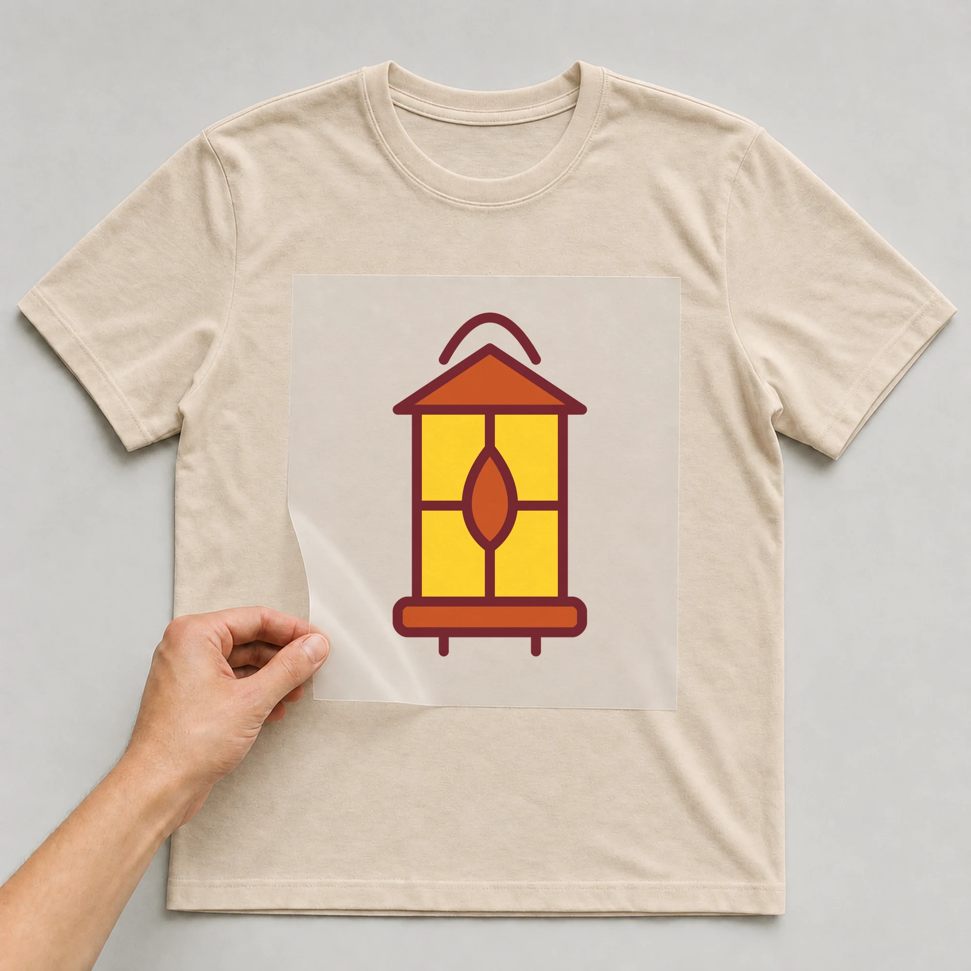 Bügelbild „Laterne eckig“ auf beigem T-Shirt, Folie wird aufgelegt