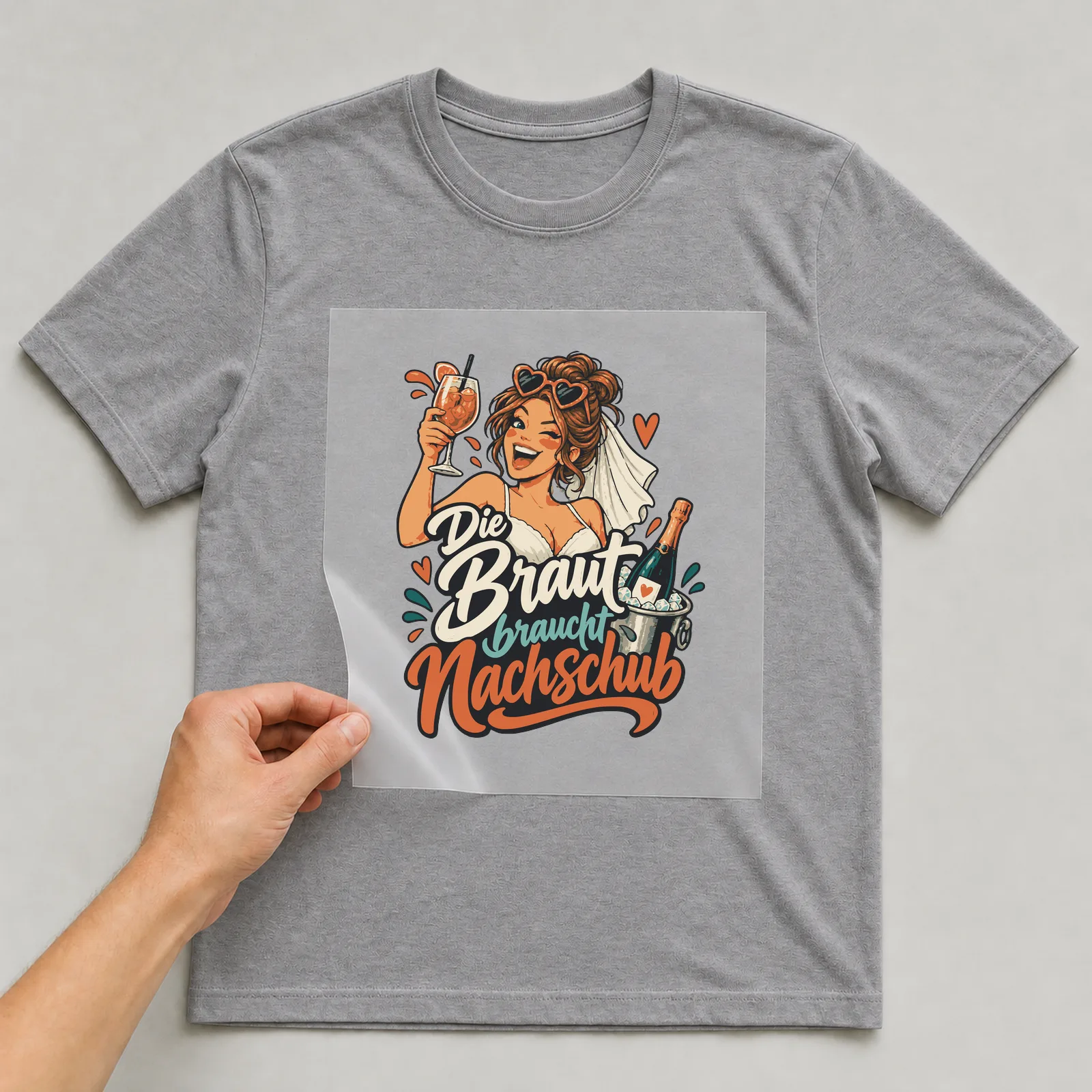 Bügelbild Die Braut braucht Nachschub auf grauem T-Shirt, Folie wird aufgelegt