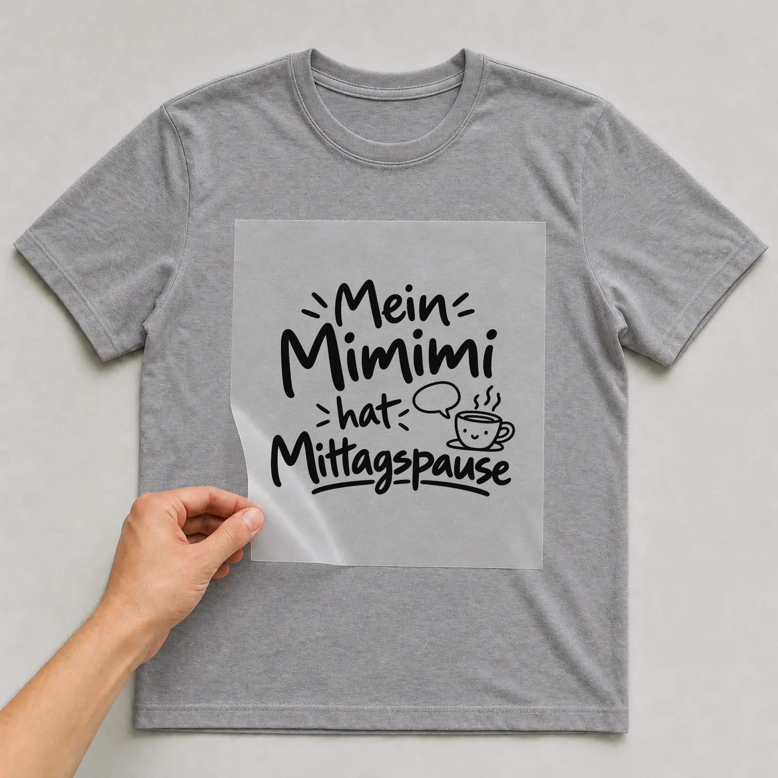 Bügelbild „Mein Mimimi hat Mittagspause“ auf grauem T-Shirt, Folie wird aufgelegt