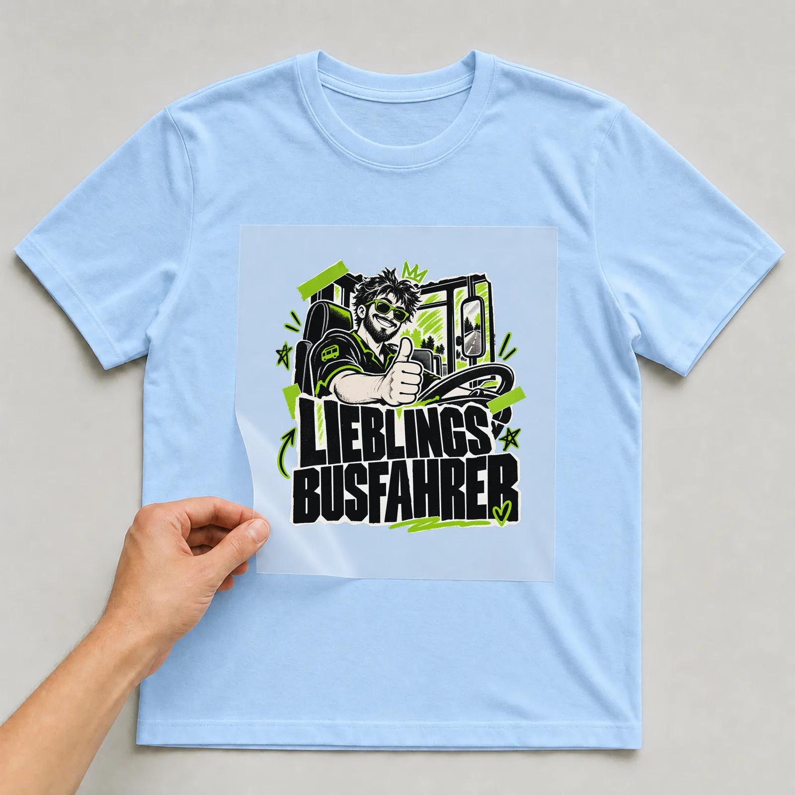 Bügelbild „Lieblingsbusfahrer“ auf hellblauem T-Shirt, Folie wird aufgelegt