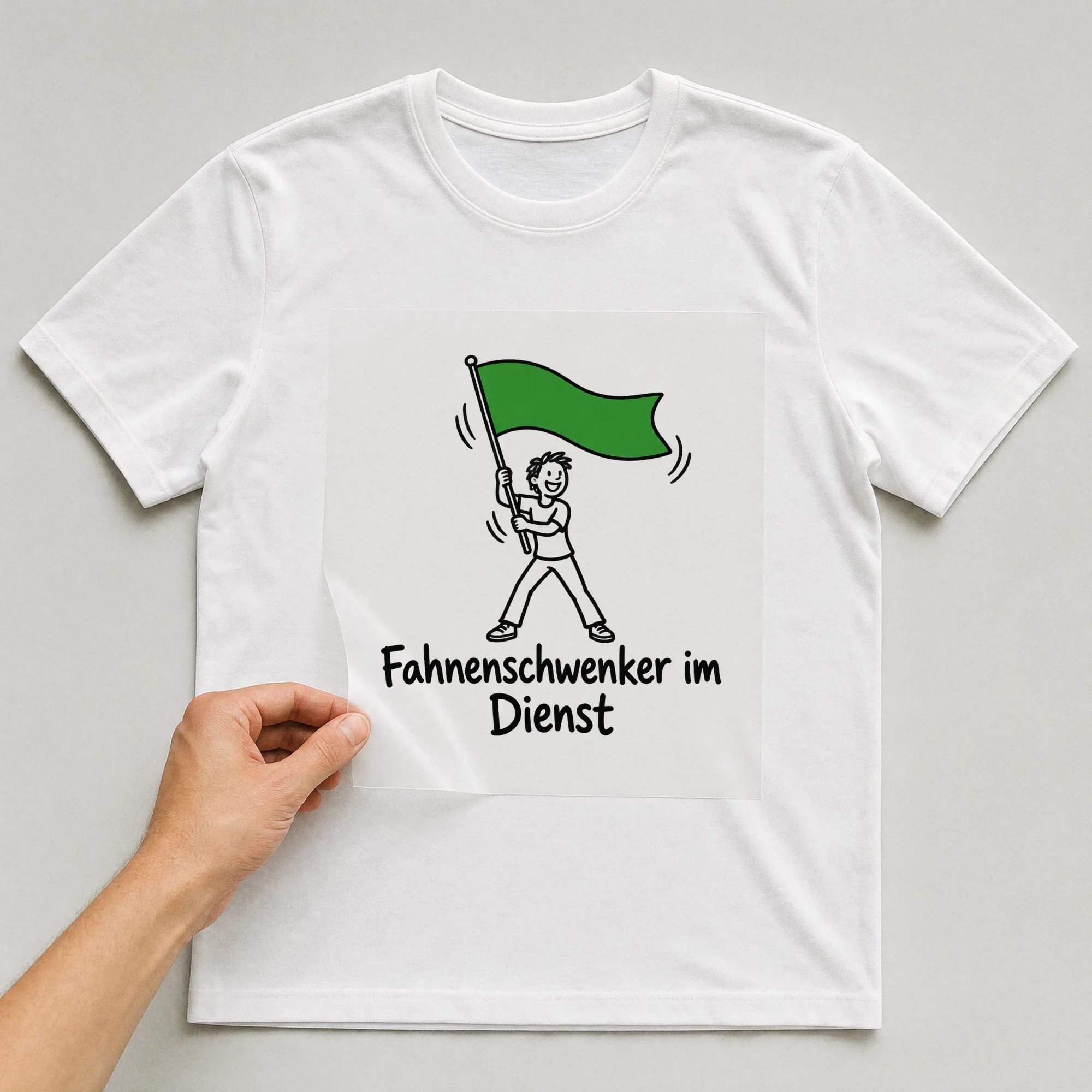 Bügelbild „Fahnenschwenker im Dienst“ auf weißem T-Shirt, Folie wird aufgelegt
