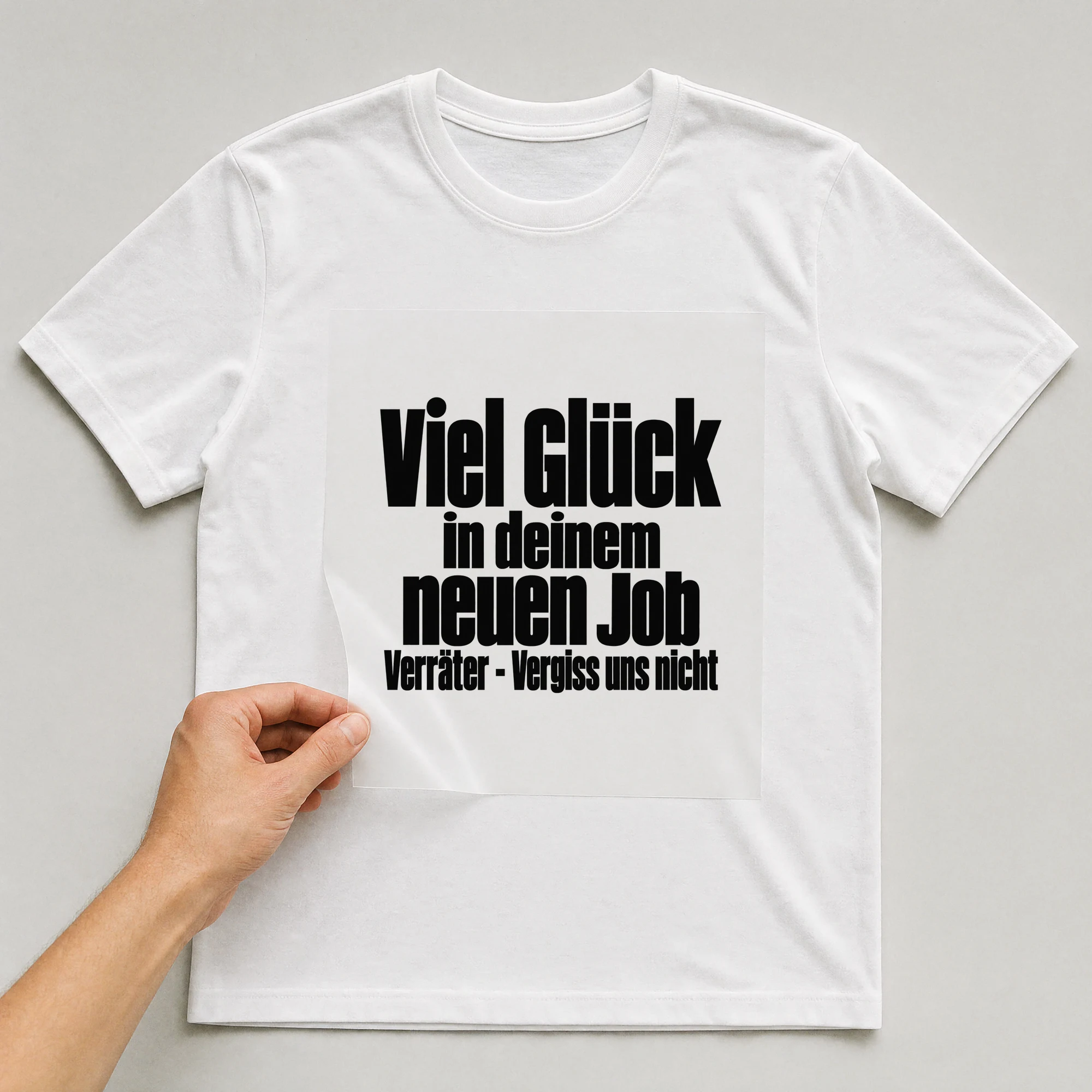 Bügelbild „Viel Glück in deinem neuen Job Verräter - Vergiss uns nicht“ auf weißem T-Shirt, Folie wird aufgelegt