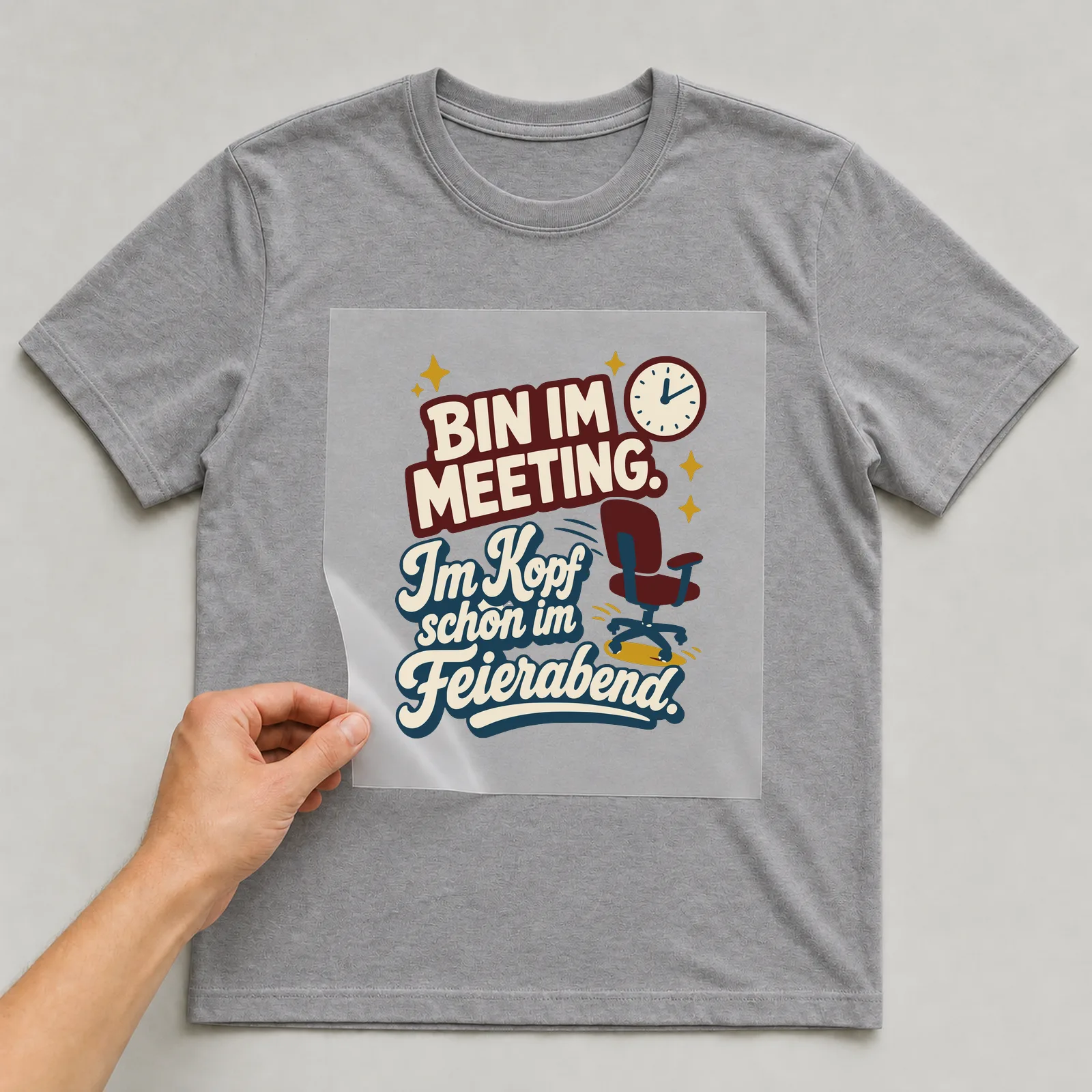 Bügelbild Bin im Meeting. Im Kopf schon im Feierabend. auf grauem T-Shirt, Folie wird aufgelegt