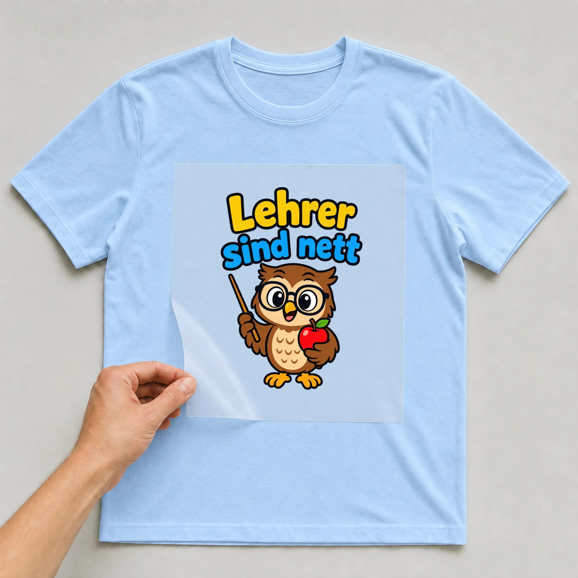 Bügelbild „Lehrer sind nett“ auf babyblauem T-Shirt, Folie wird aufgelegt