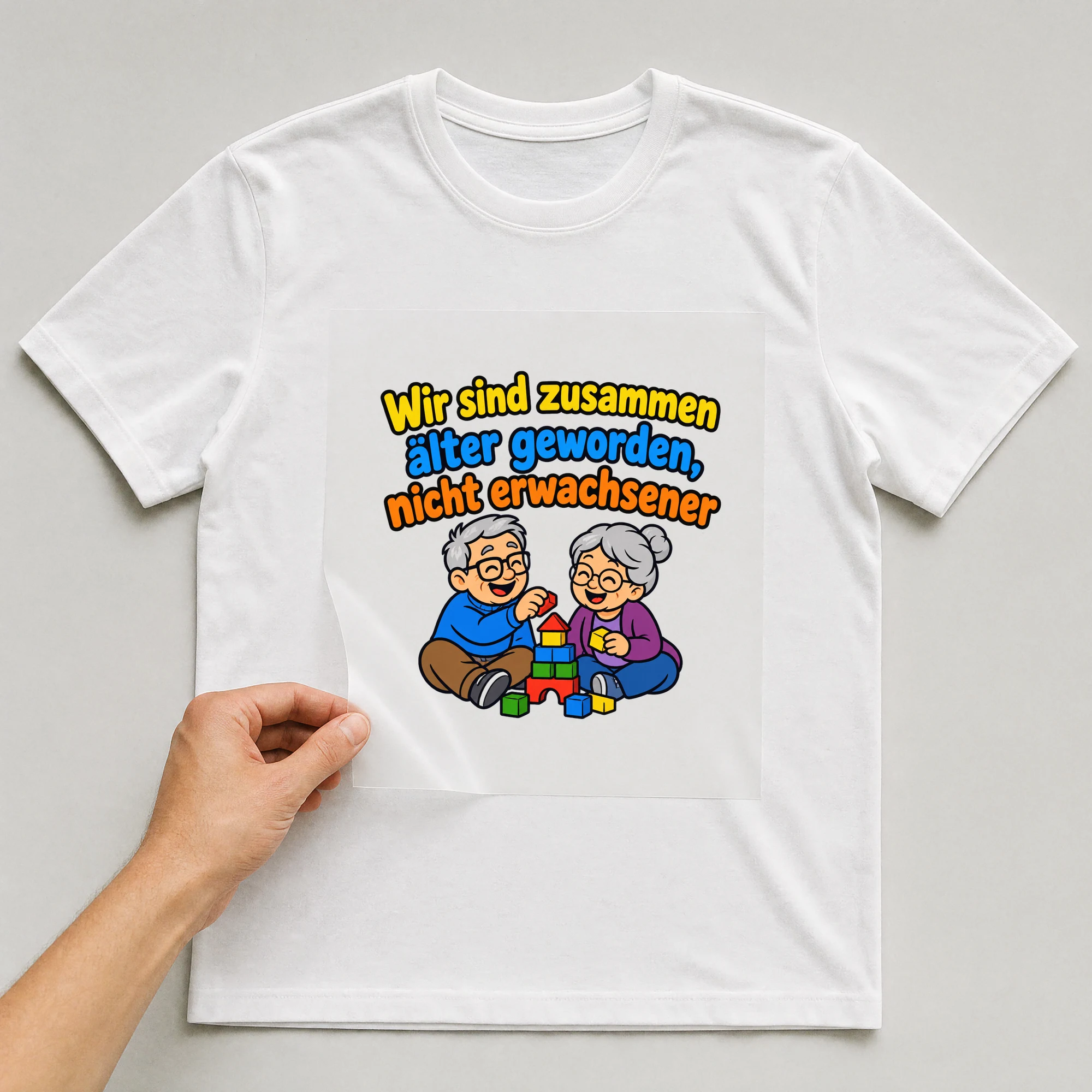Bügelbild „Wir sind zusammen älter geworden, nicht erwachsener“ auf weißem T-Shirt, Folie wird aufgelegt