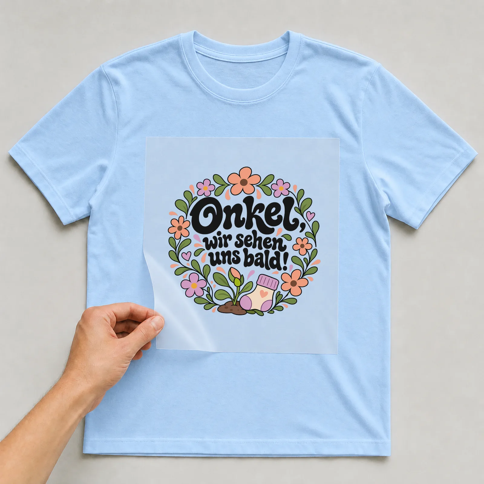 Bügelbild „Onkel, wir sehen uns bald!“ auf hellblauem T-Shirt, Folie wird aufgelegt