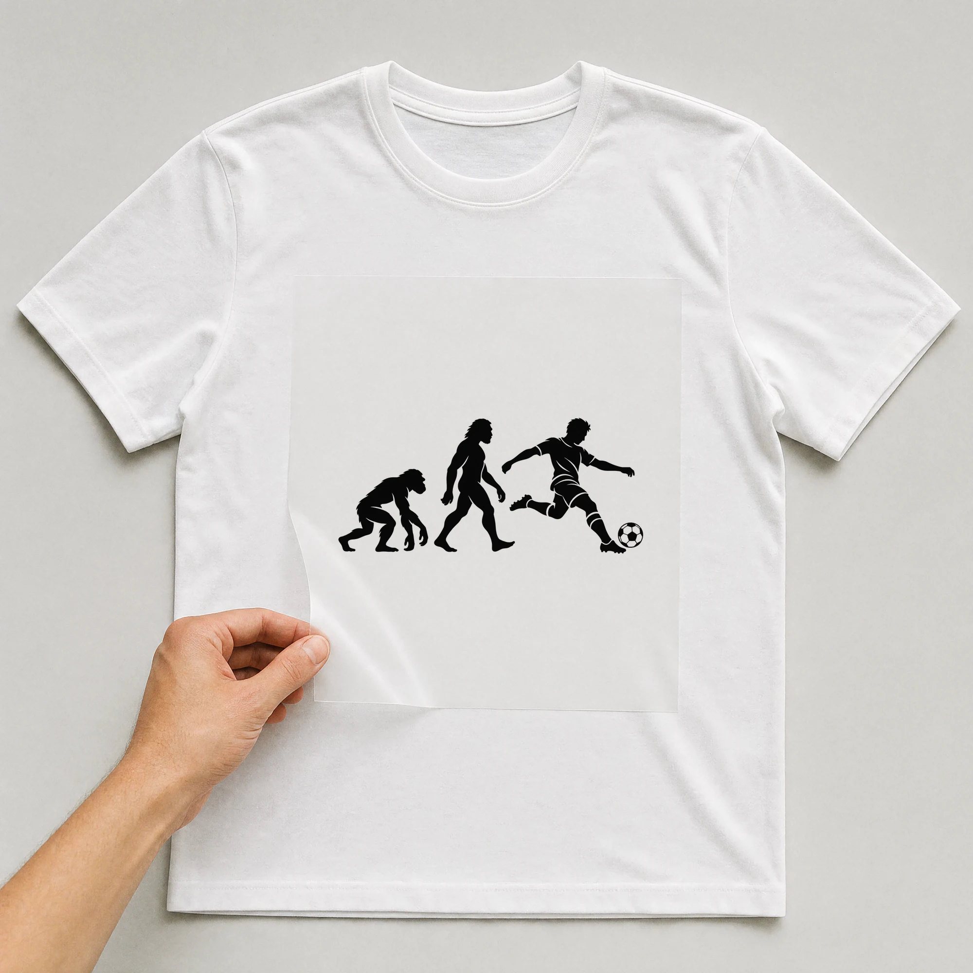 Bügelbild „Soccer Evolution“ auf weißem T-Shirt, Folie wird aufgelegt