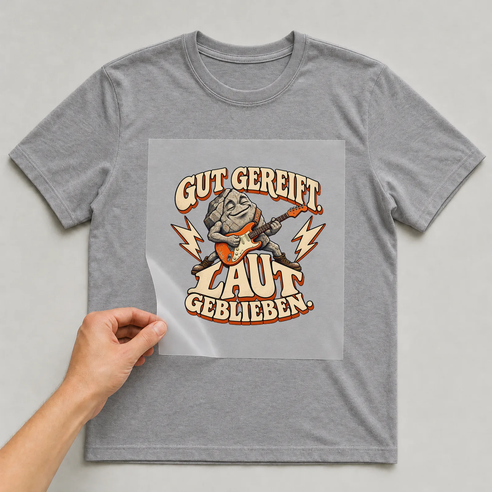 Bügelbild „Gut gereift. Laut geblieben.“ auf grauem T-Shirt, Folie wird aufgelegt