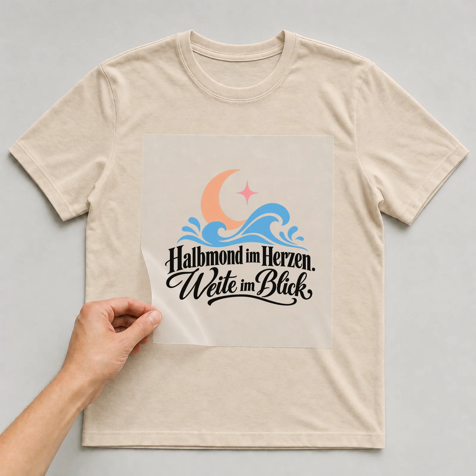 Bügelbild „Halbmond im Herzen. Weite im Blick.“ auf beigem T-Shirt, Folie wird aufgelegt