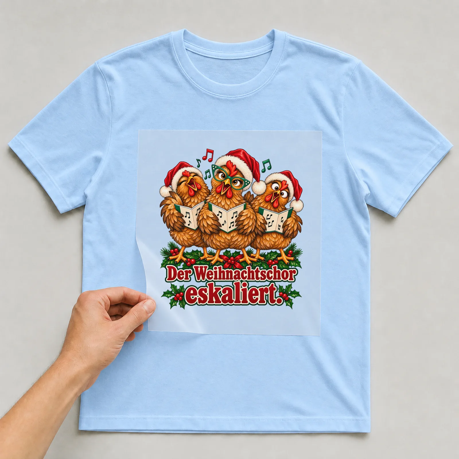 Bügelbild huhn weihnachtschor auf hellblauem T-Shirt, Folie wird aufgelegt