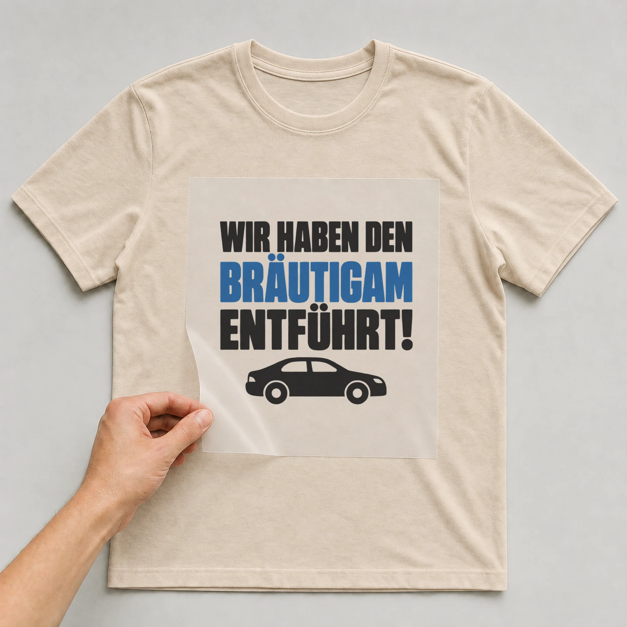 Bügelbild „Wir haben den Bräutigam entführt!“ auf babyblauem T-Shirt, Folie wird aufgelegt