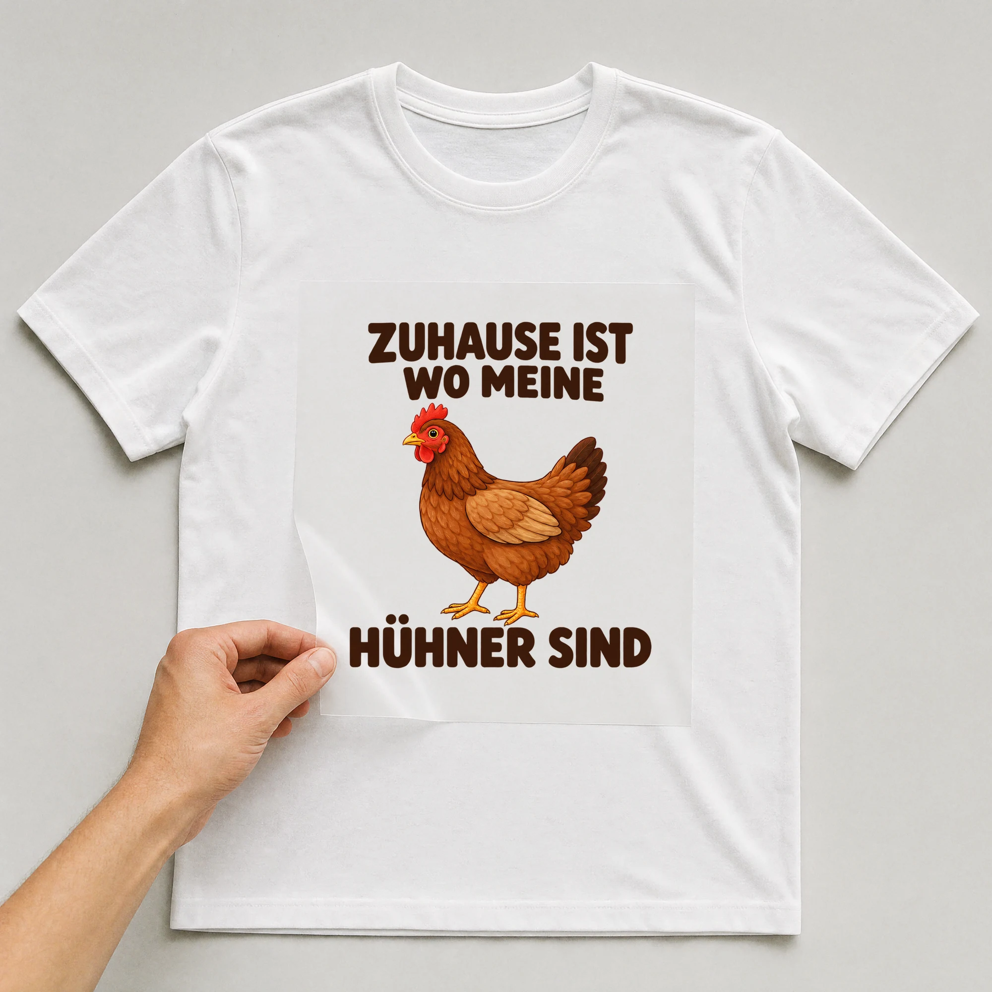 Bügelbild „Zuhause ist wo meine Hühner sind“ auf weißem T-Shirt, Folie wird aufgelegt