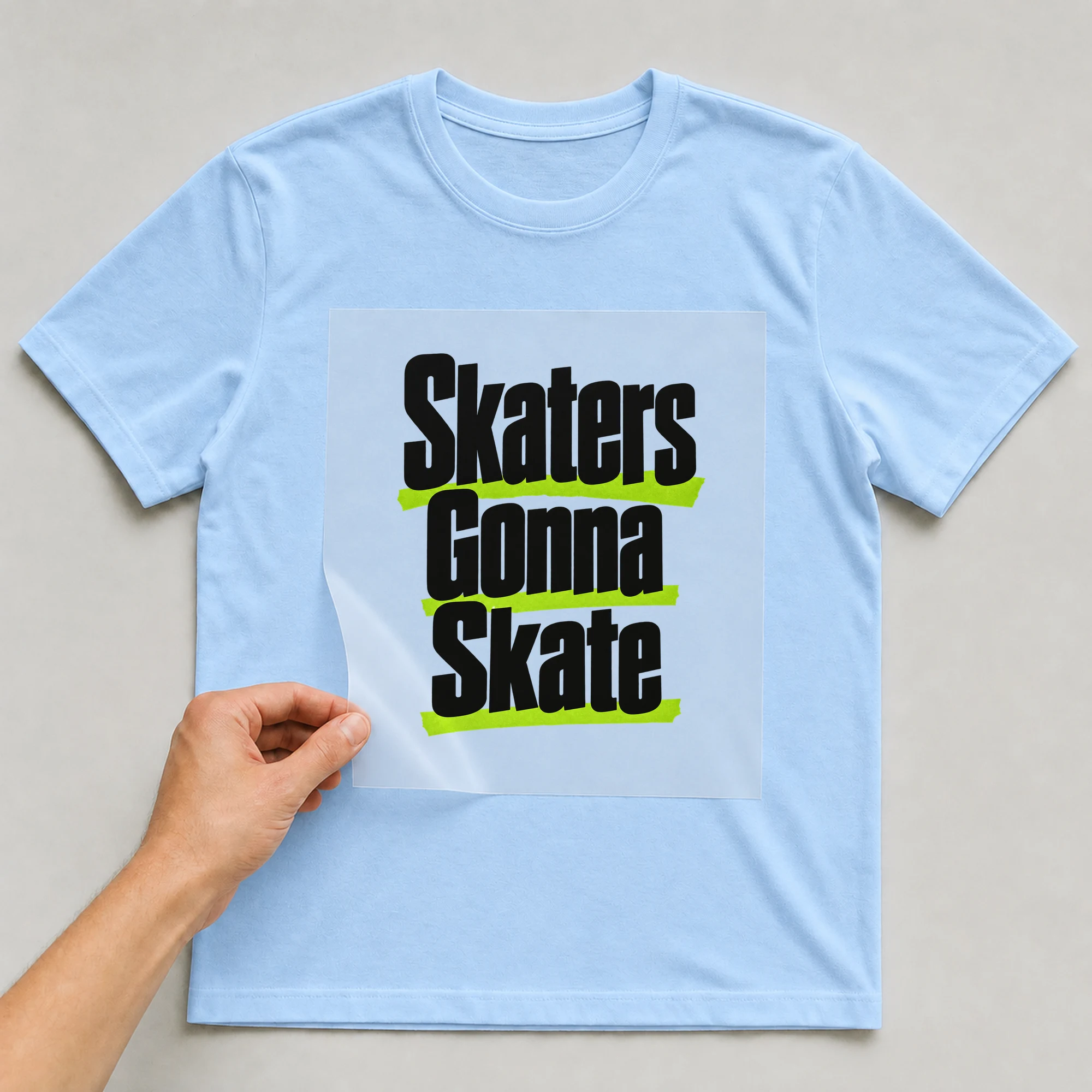 Bügelbild „Skaters Gonna Skate“ auf babyblauem T-Shirt, Folie wird aufgelegt