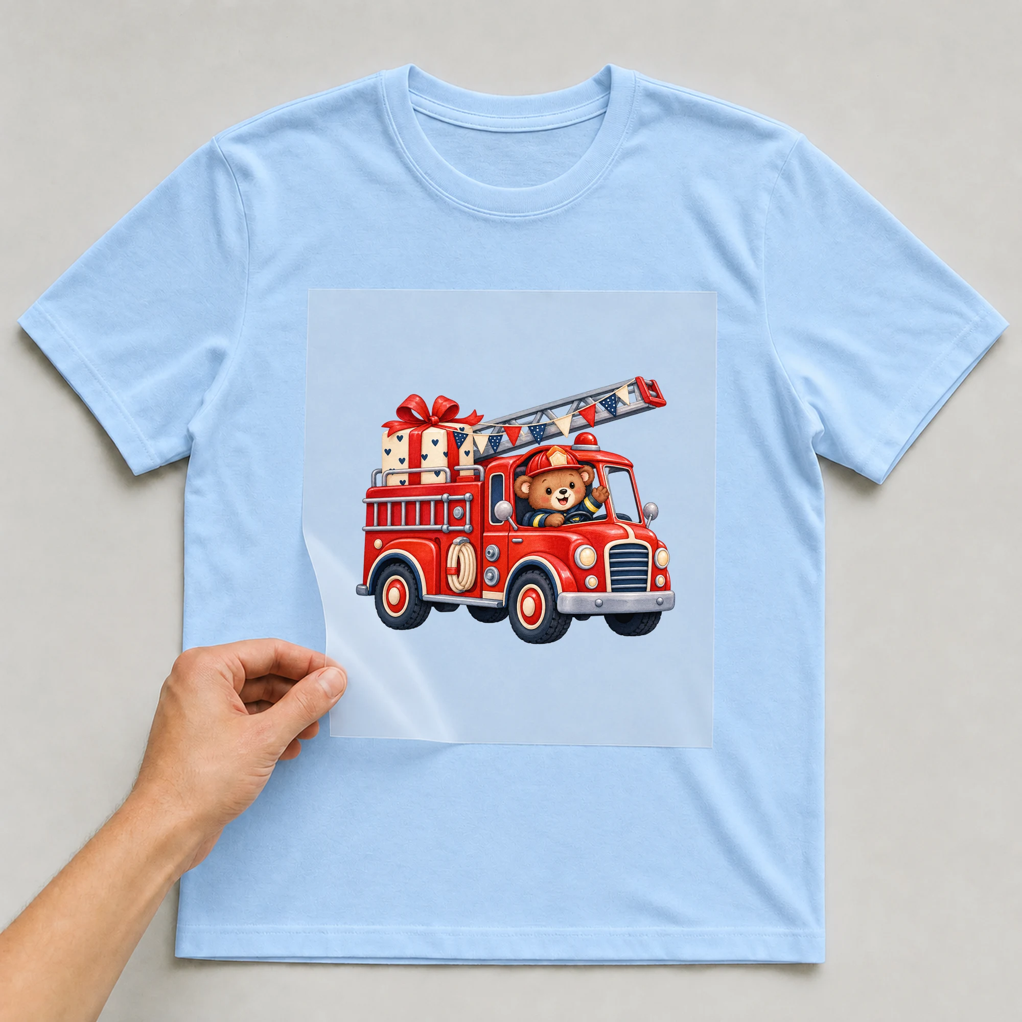Bügelbild „Feuerwehr zur Party“ auf babyblauem T-Shirt, Folie wird aufgelegt