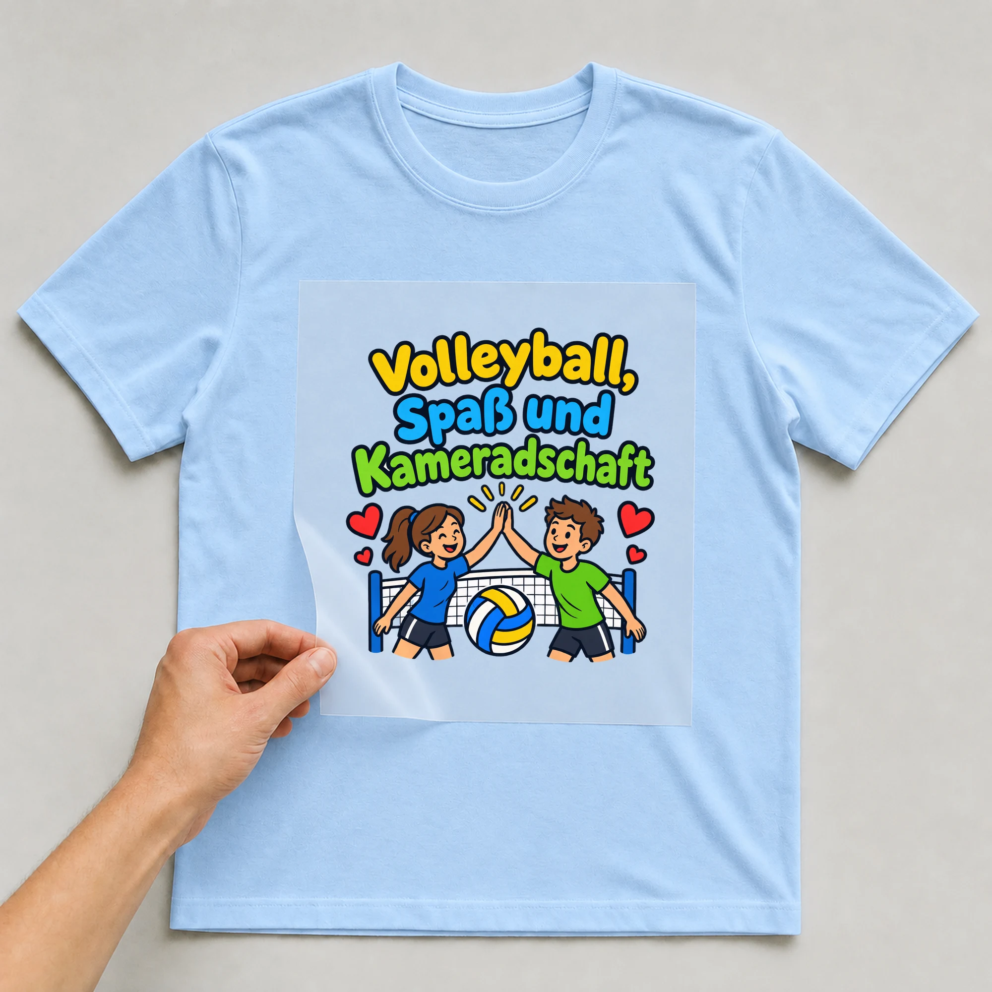 Bügelbild „Volleyball, Spaß und Kameradschaft“ auf babyblauem T-Shirt, Folie wird aufgelegt