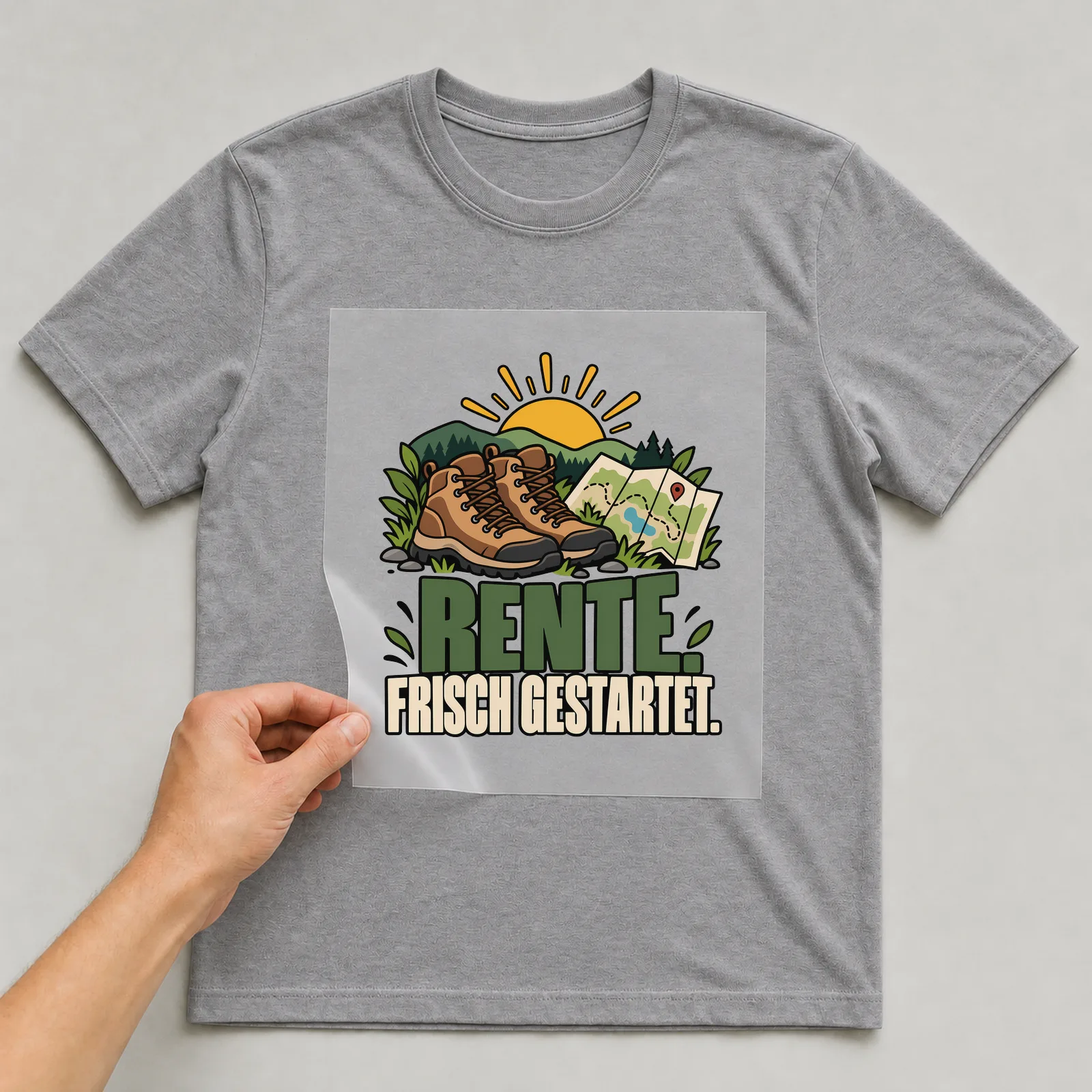 Bügelbild „Rente. Frisch gestartet.“ auf grauem T-Shirt, Folie wird aufgelegt