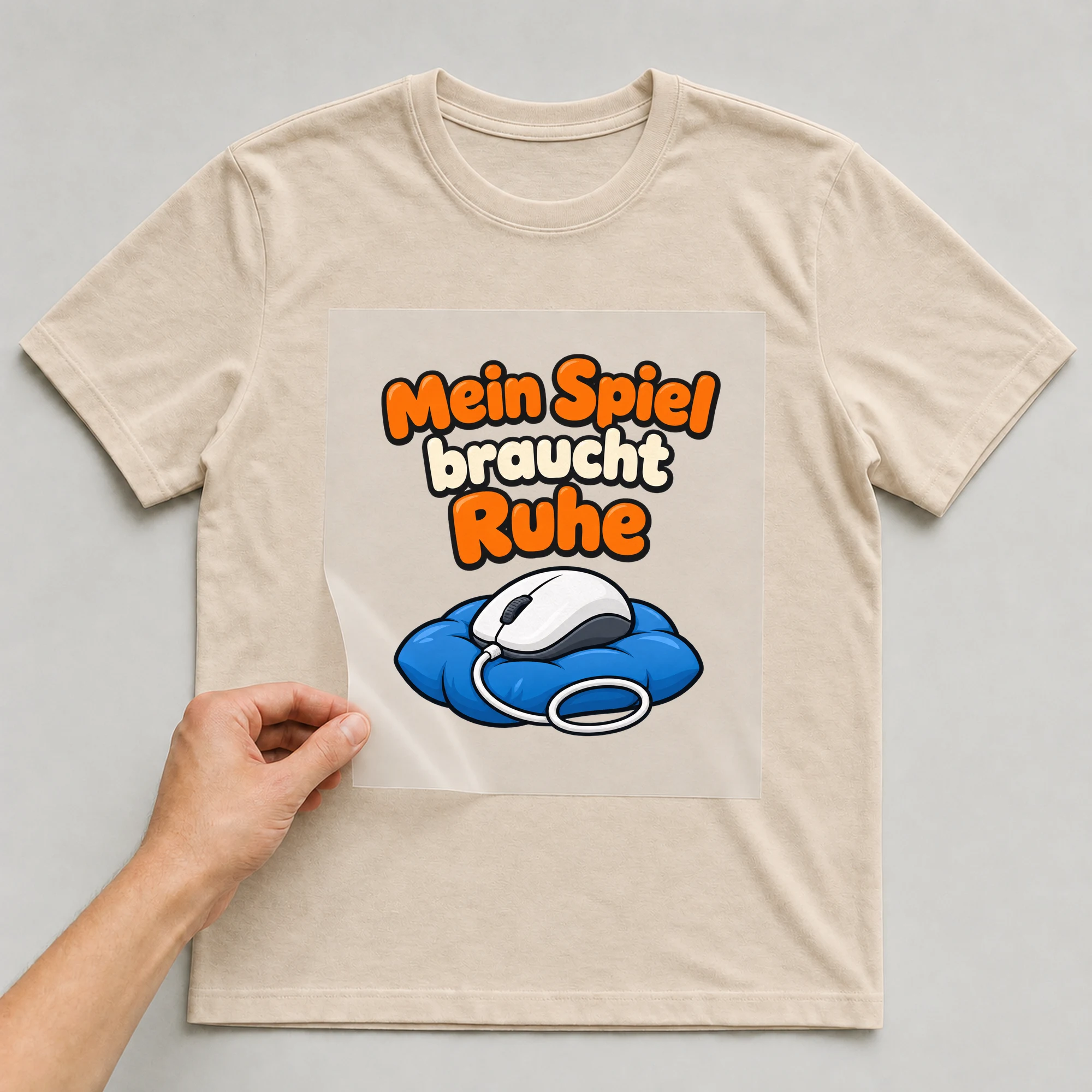 Bügelbild „Mein Spiel braucht Ruhe“ auf beigem T-Shirt, Folie wird aufgelegt