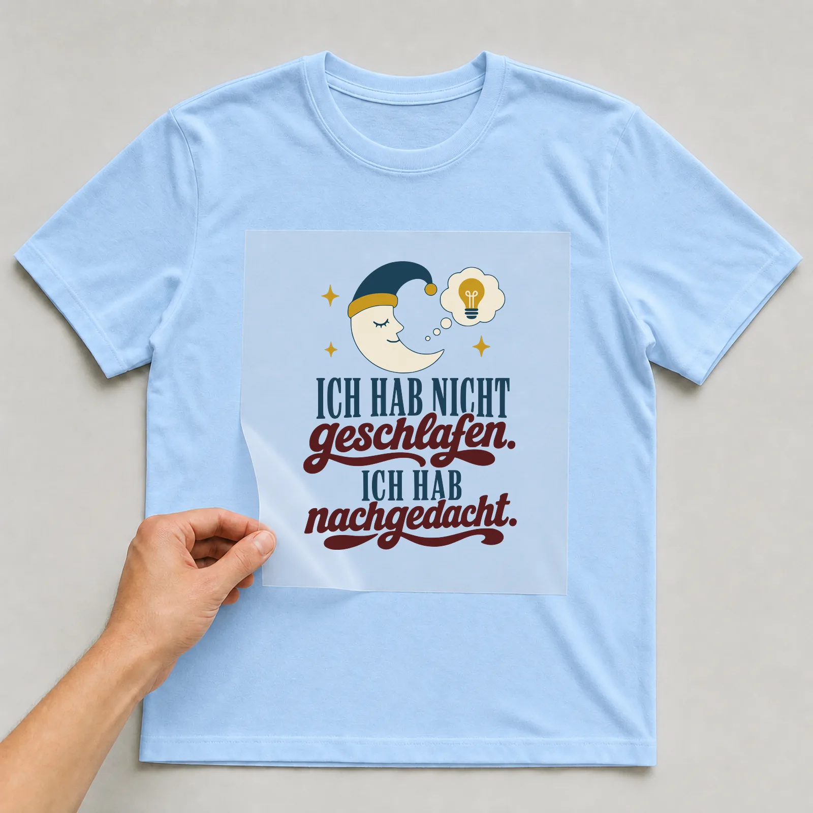 Bügelbild Ich hab nicht geschlafen. Ich hab nachgedacht. auf hellblauem T-Shirt, Folie wird aufgelegt
