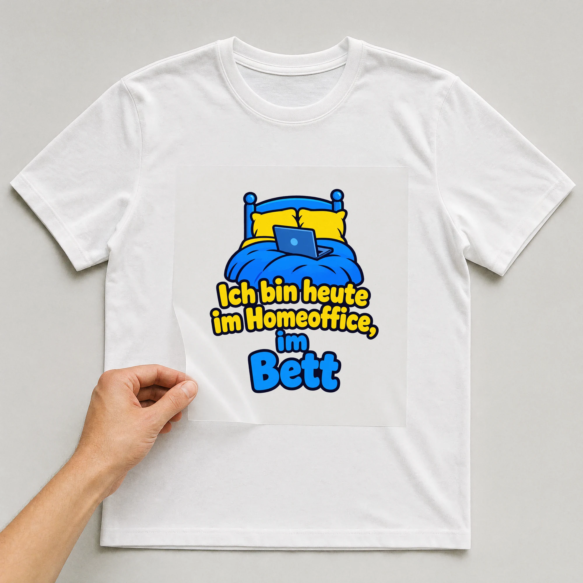 Bügelbild „Ich bin heute im Homeoffice, im Bett“ auf weißem T-Shirt, Folie wird aufgelegt