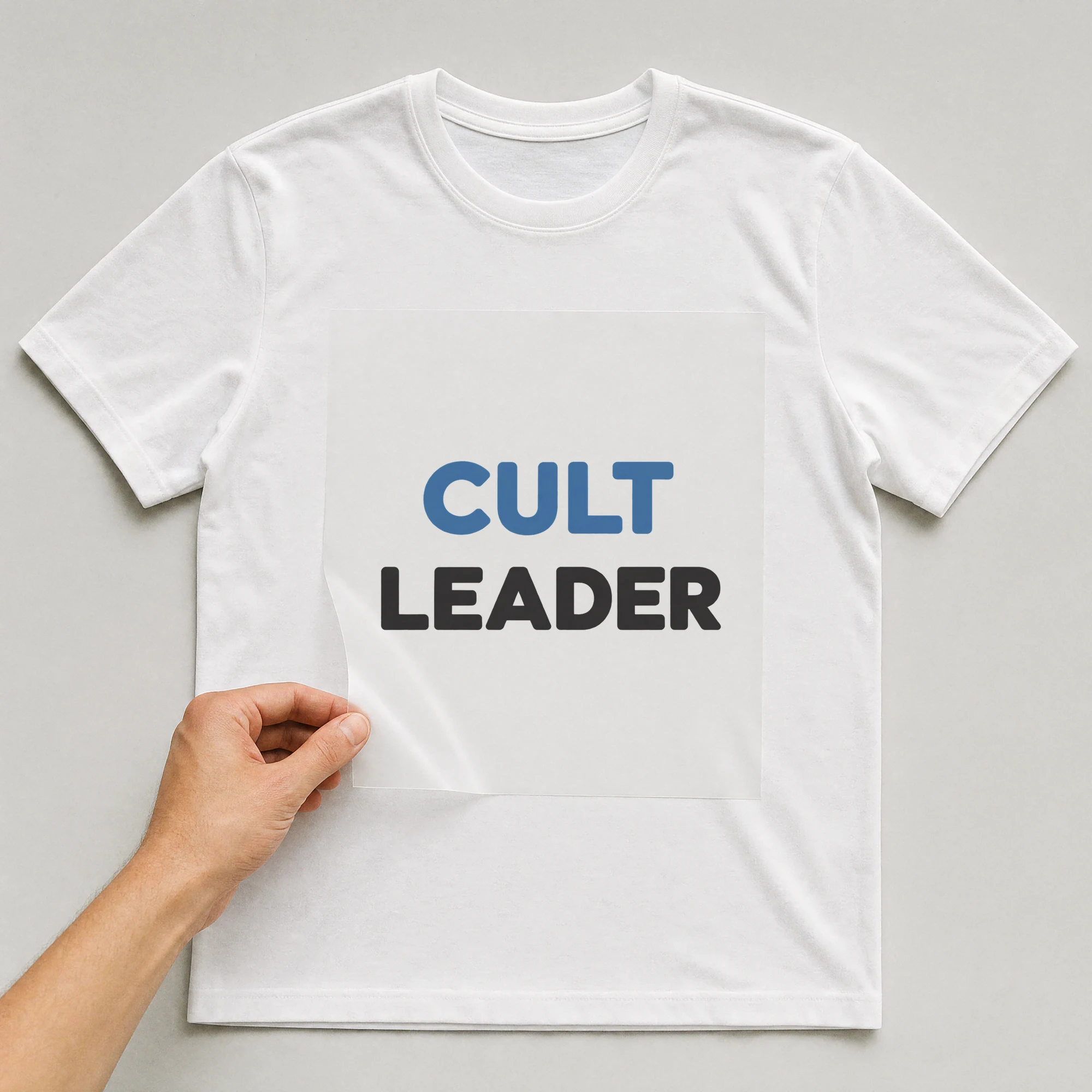 Bügelbild „CULT LEADER“ auf weißem T-Shirt, Folie wird aufgelegt