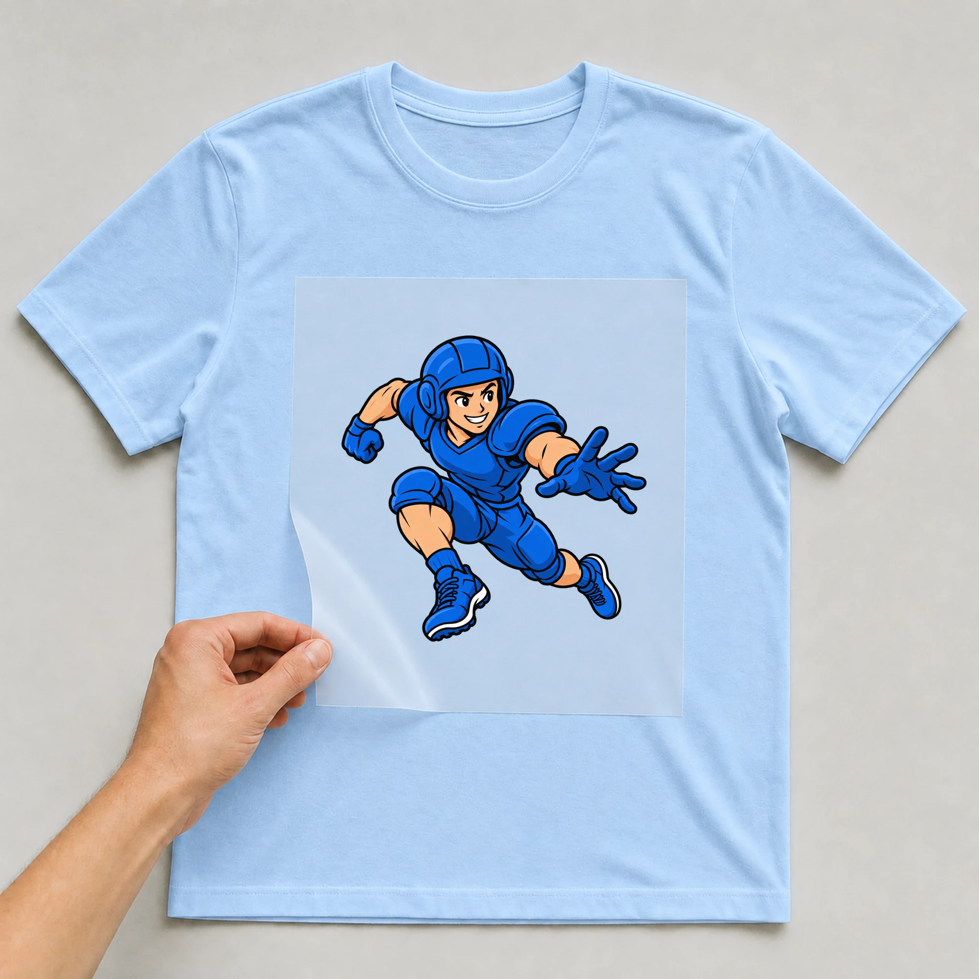 Bügelbild „Rugby“ auf babyblauem T-Shirt, Folie wird aufgelegt