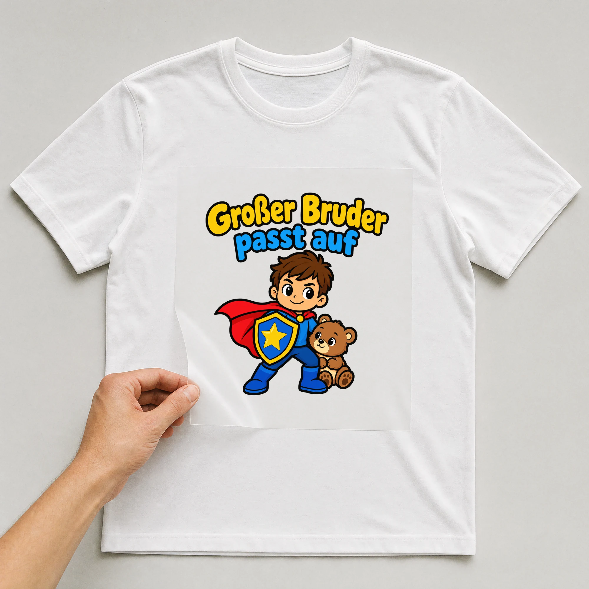 Bügelbild „Großer Bruder passt auf“ auf weißem T-Shirt, Folie wird aufgelegt