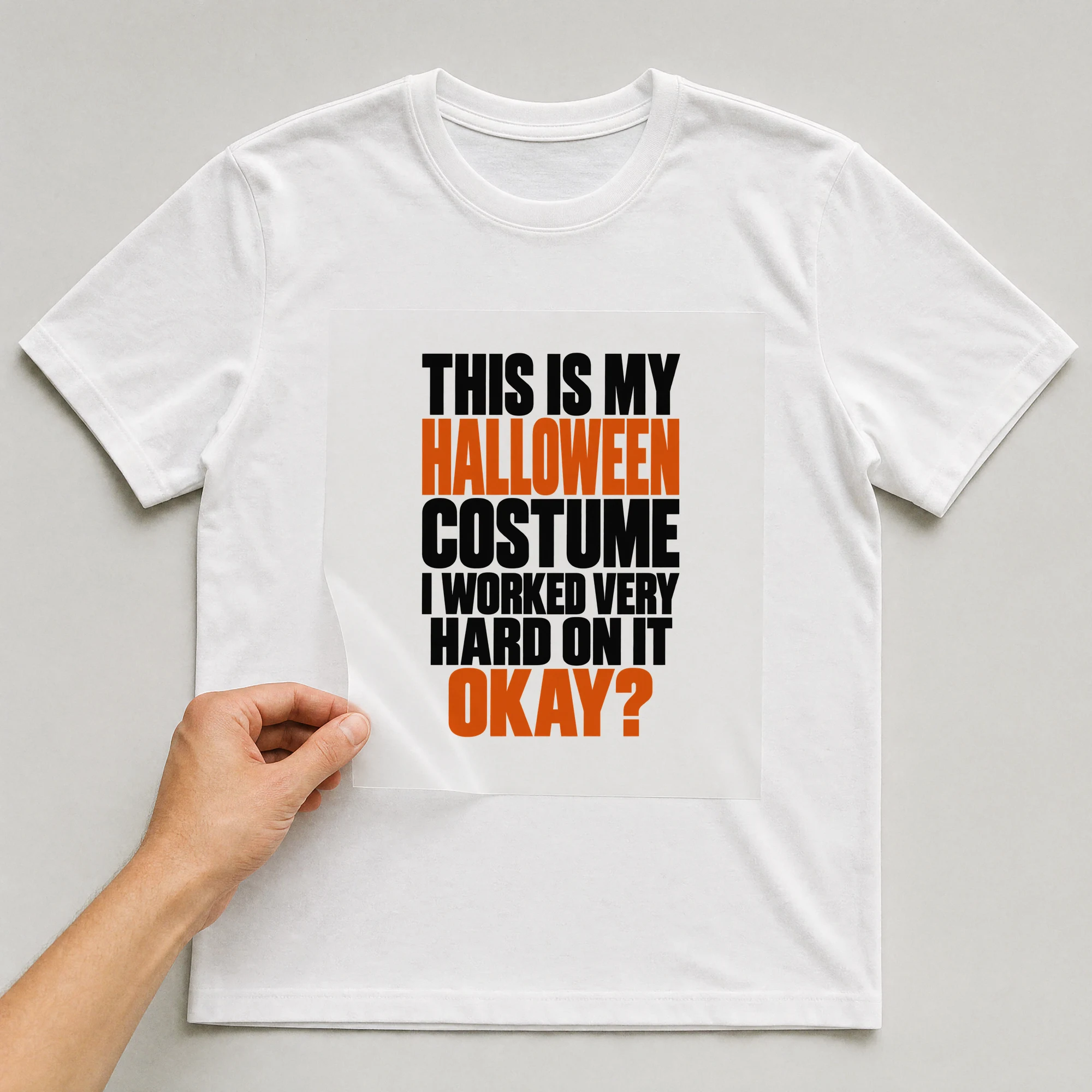 Bügelbild „This Is My Halloween Costume I Worked Very Hard On It Okay?“ auf weißem T-Shirt, Folie wird aufgelegt