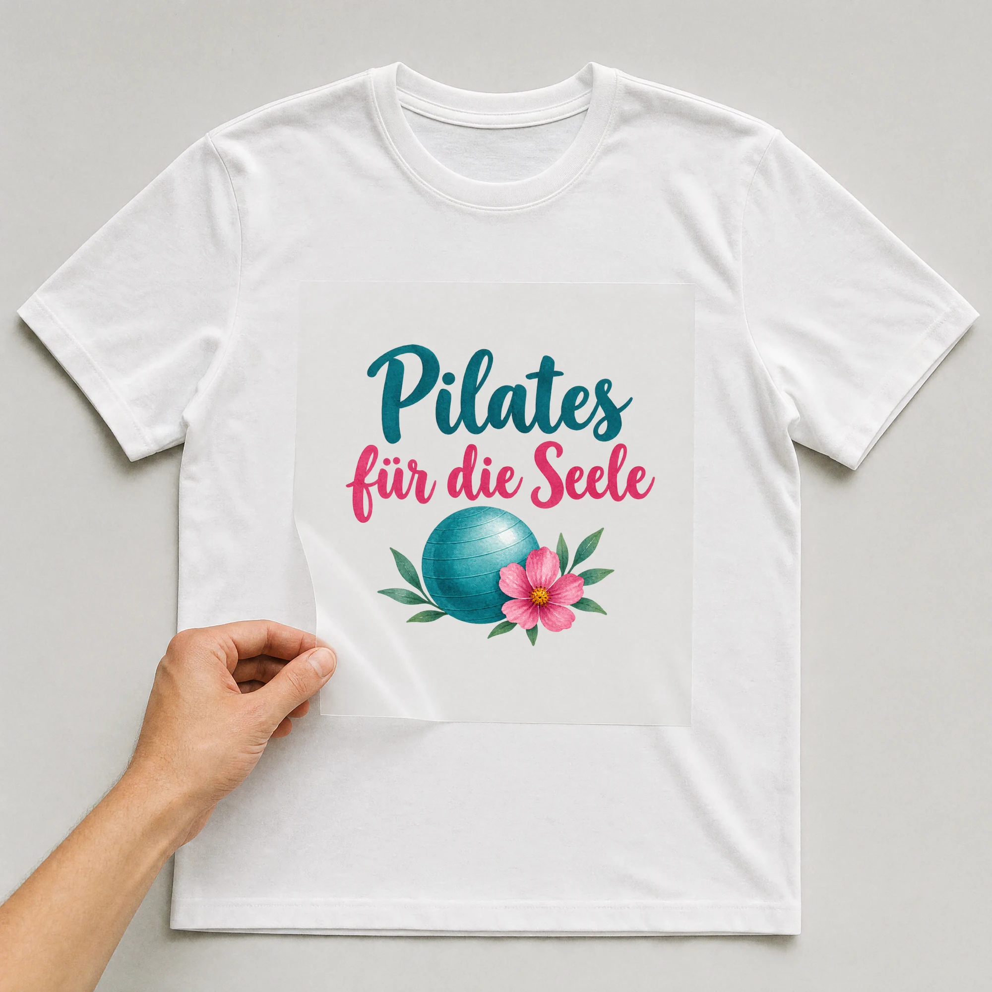 Bügelbild „Pilates für die Seele“ auf weißem T-Shirt, Folie wird aufgelegt