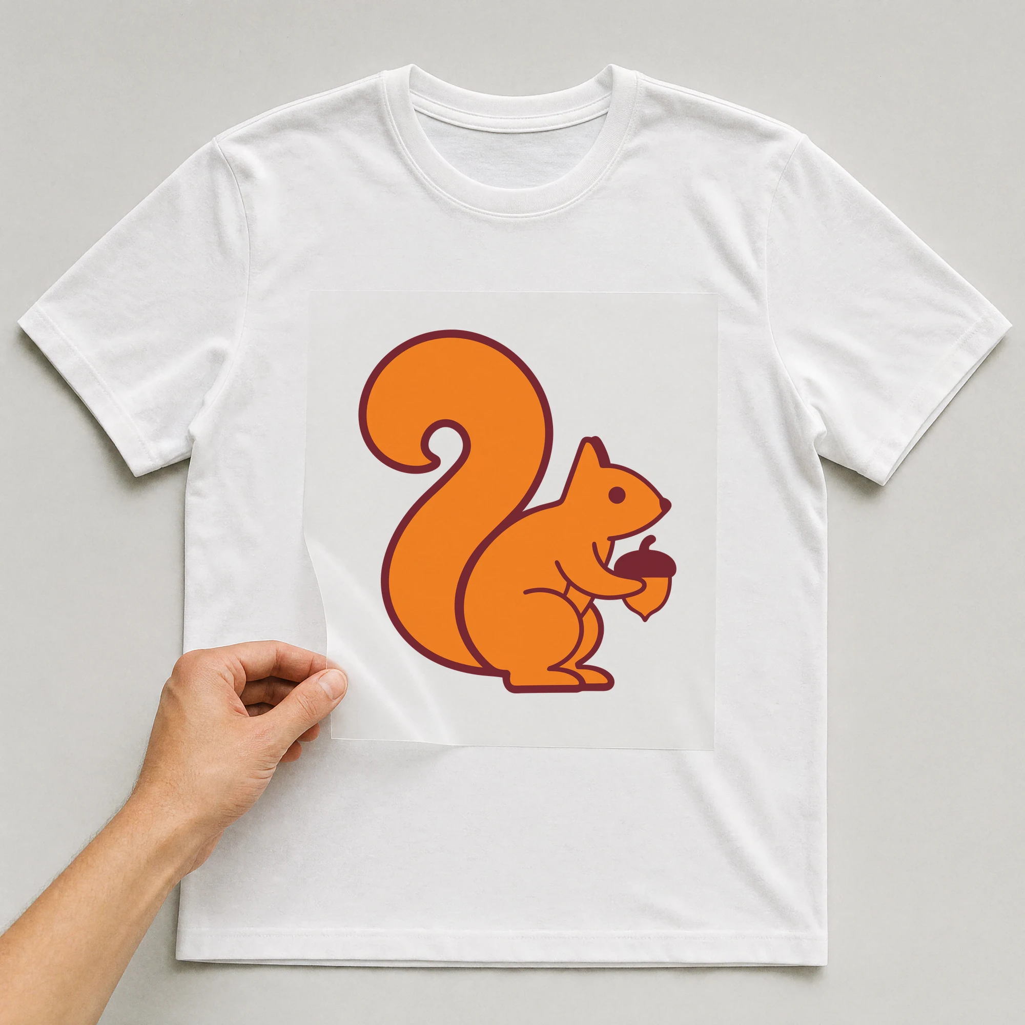 Bügelbild „Eichhörnchen“ auf weißem T-Shirt, Folie wird aufgelegt