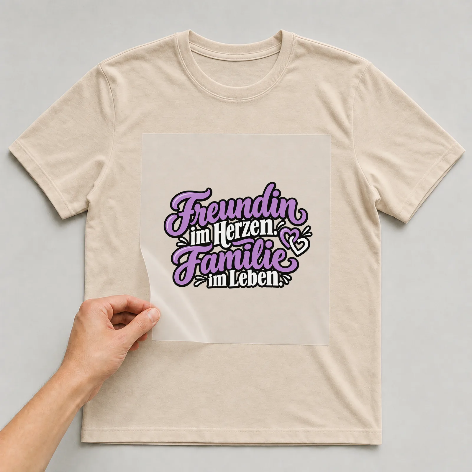 Bügelbild „Freundin im Herzen. Familie im Leben.“ auf beigem T-Shirt, Folie wird aufgelegt