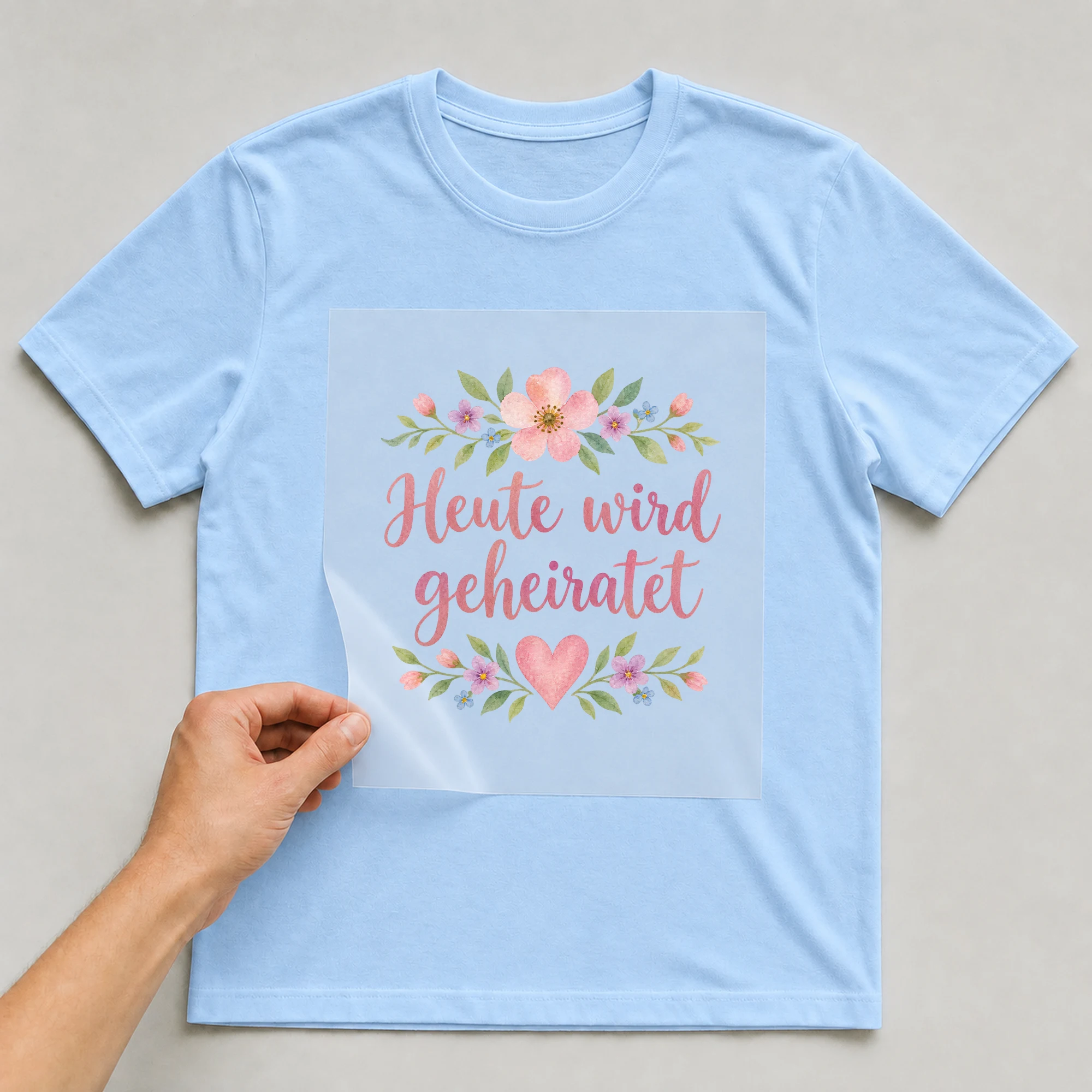 Bügelbild „Heute wird geheiratet“ auf babyblauem T-Shirt, Folie wird aufgelegt