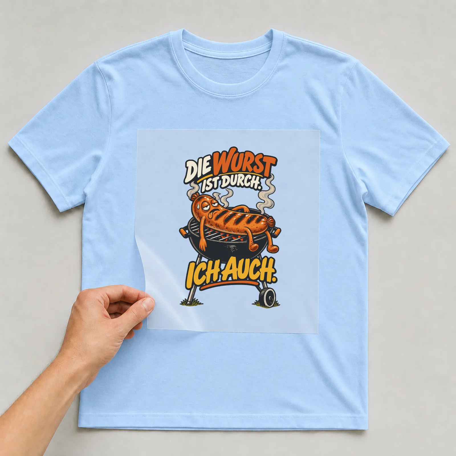 Bügelbild Die Wurst ist durch. Ich auch. auf hellblauem T-Shirt, Folie wird aufgelegt