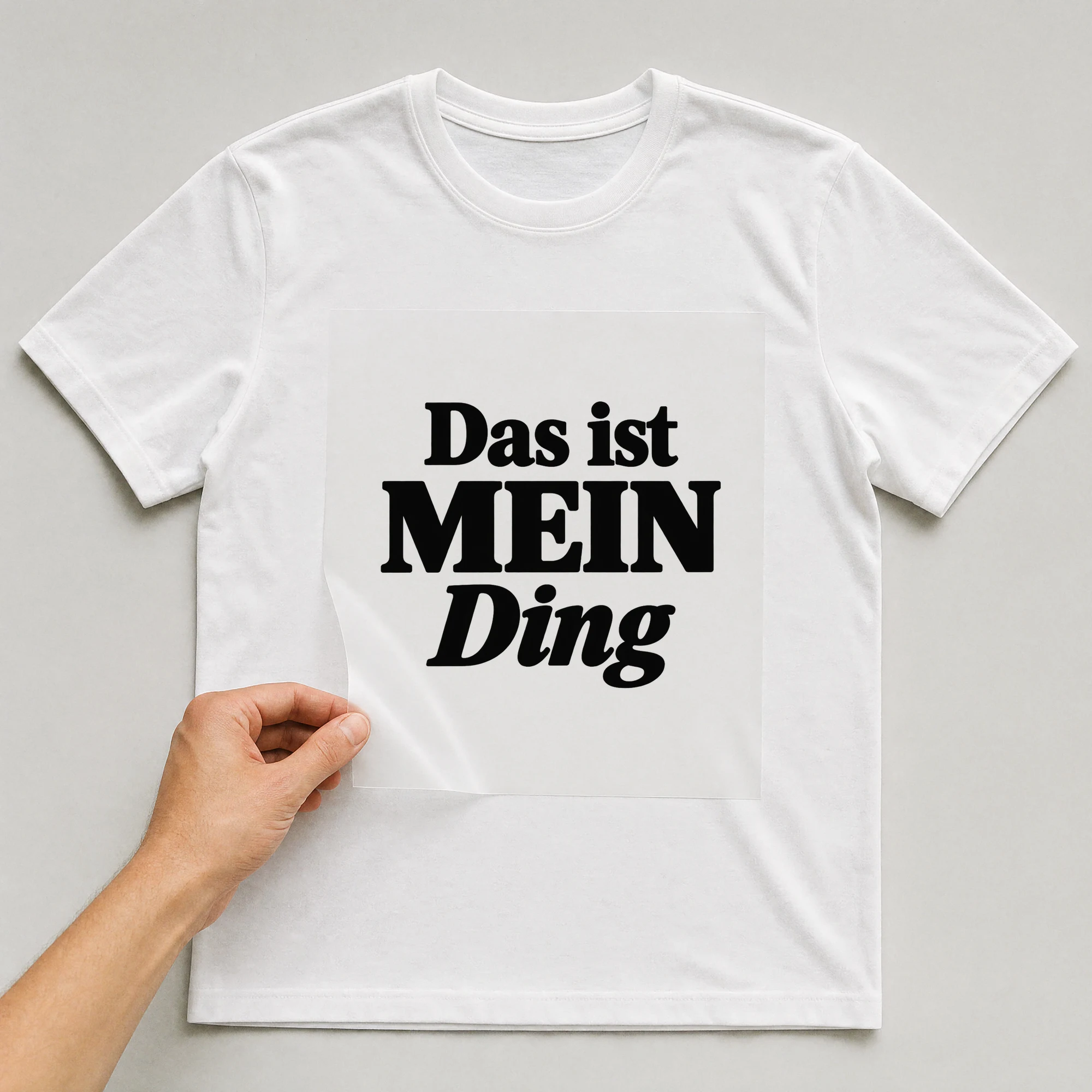 Bügelbild „Das ist mein Ding“ auf weißem T-Shirt, Folie wird aufgelegt