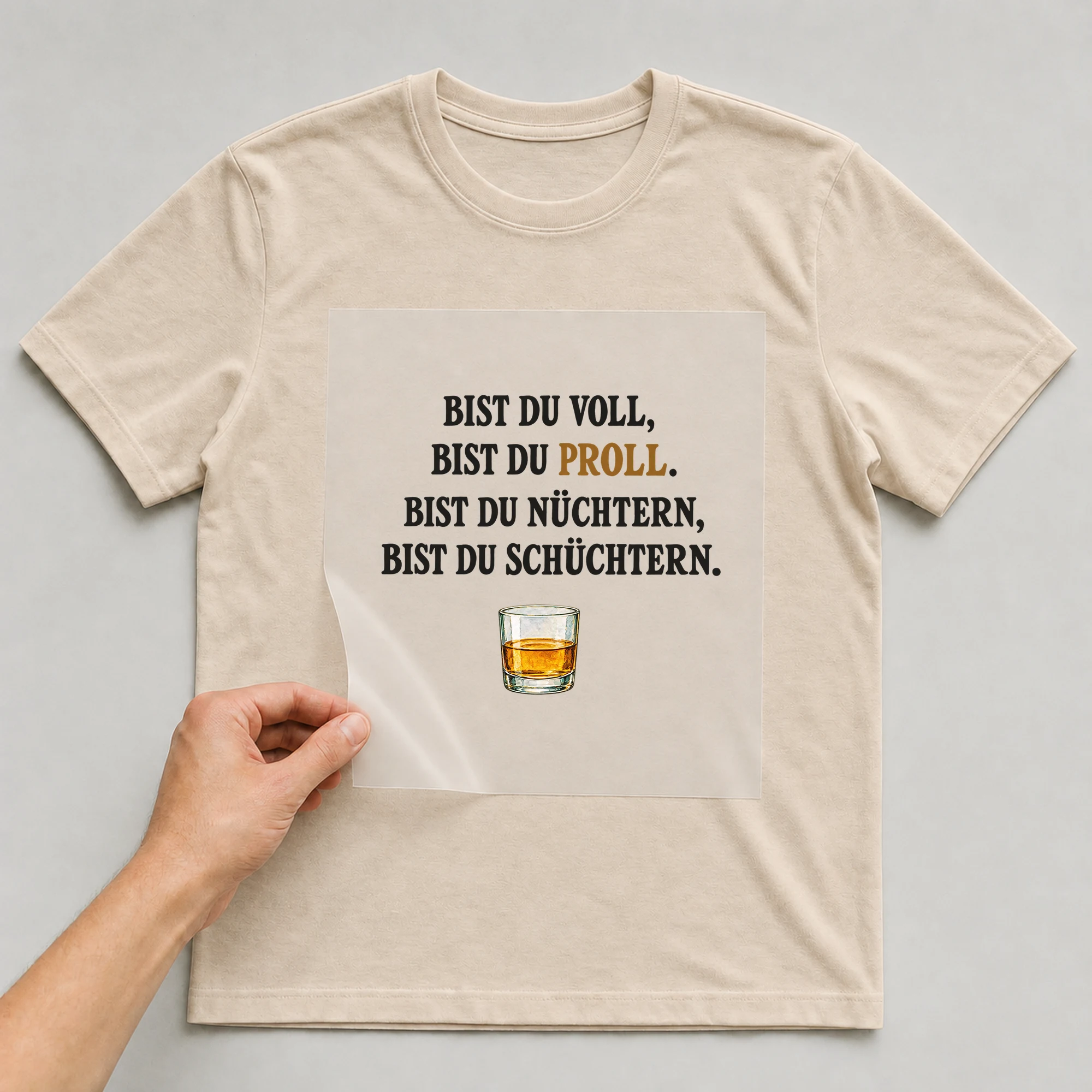 Bügelbild „BIST DU VOLL, BIST DU PROLL. BIST DU NÜCHTERN, BIST DU SCHÜCHTERN.“ auf beigem T-Shirt, Folie wird aufgelegt