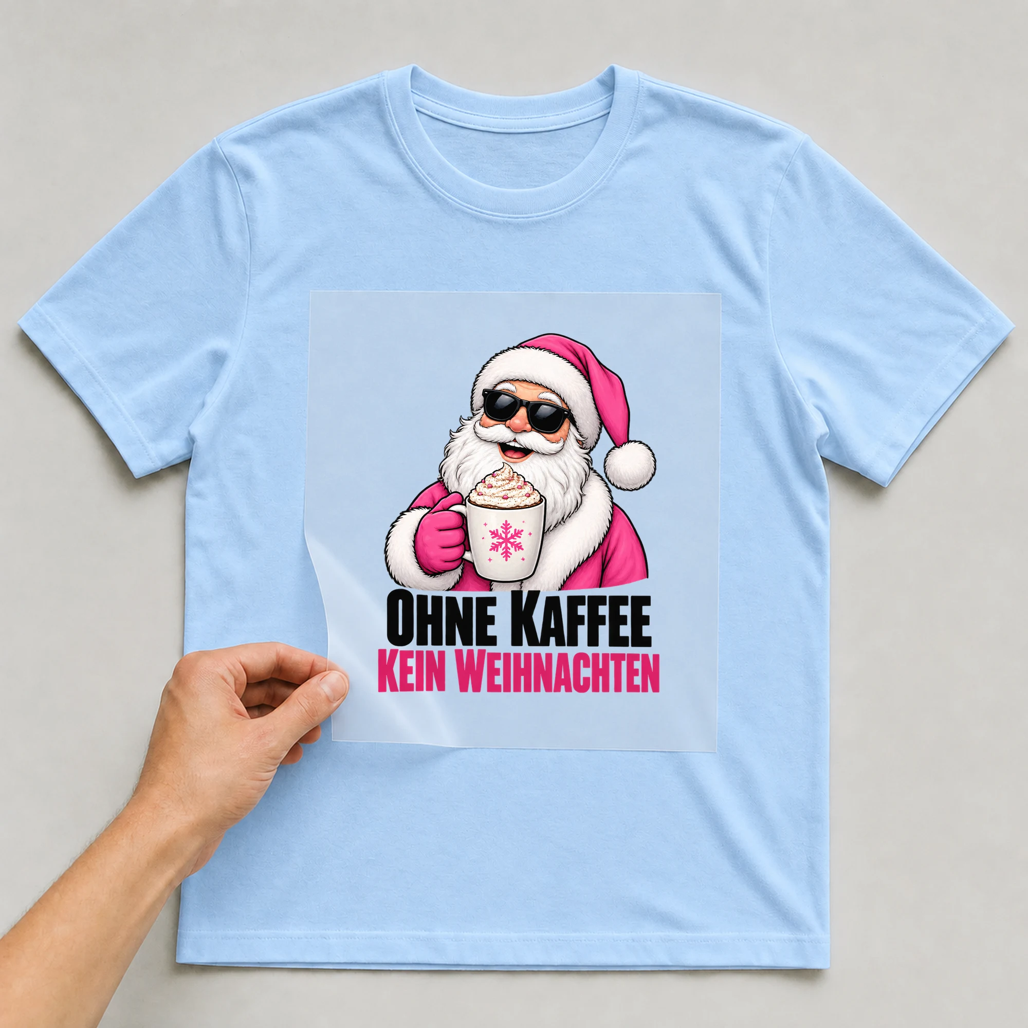 Bügelbild „Kaffee macht Weihnachten“ auf babyblauem T-Shirt, Folie wird aufgelegt