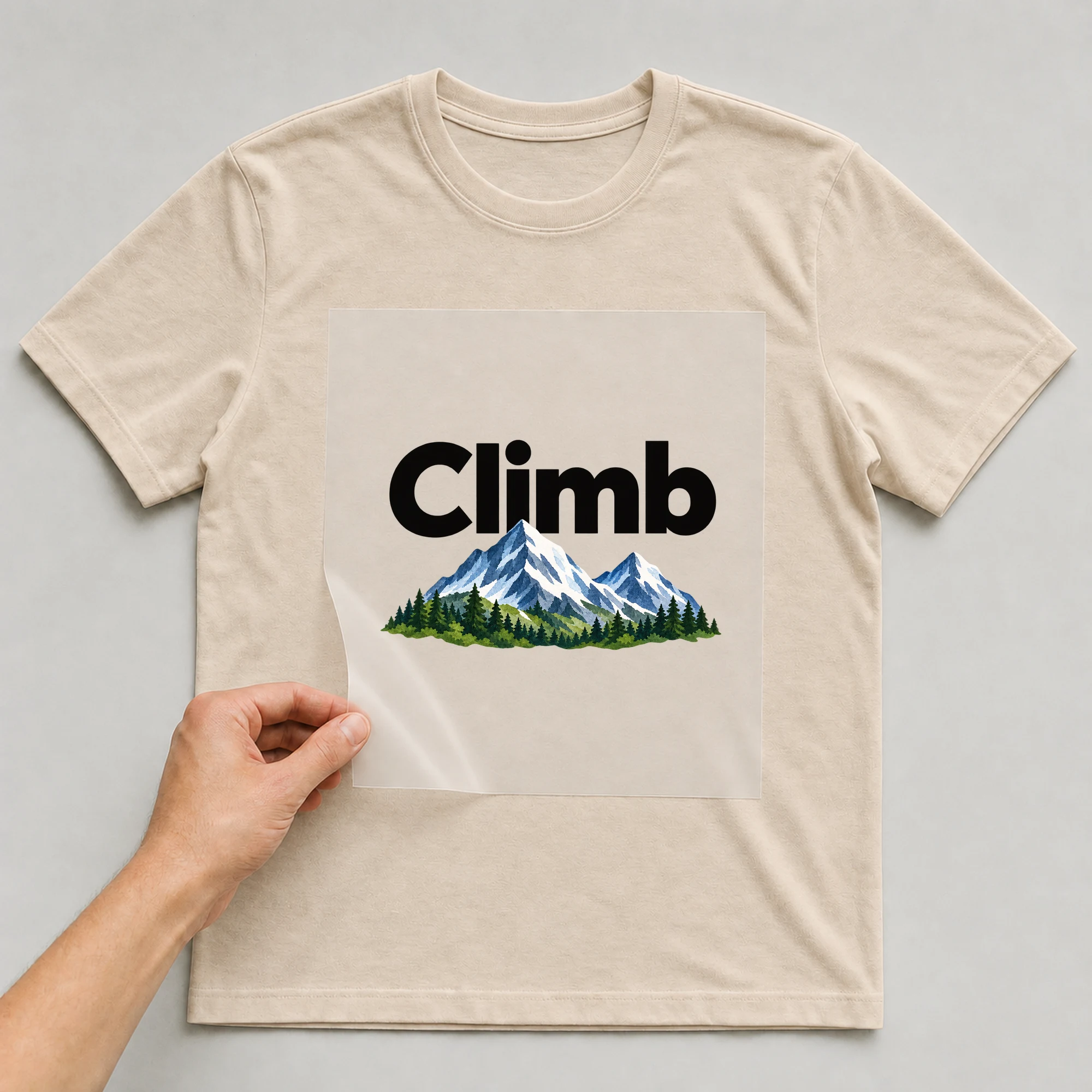 Bügelbild „Climb“ auf beigem T-Shirt, Folie wird aufgelegt