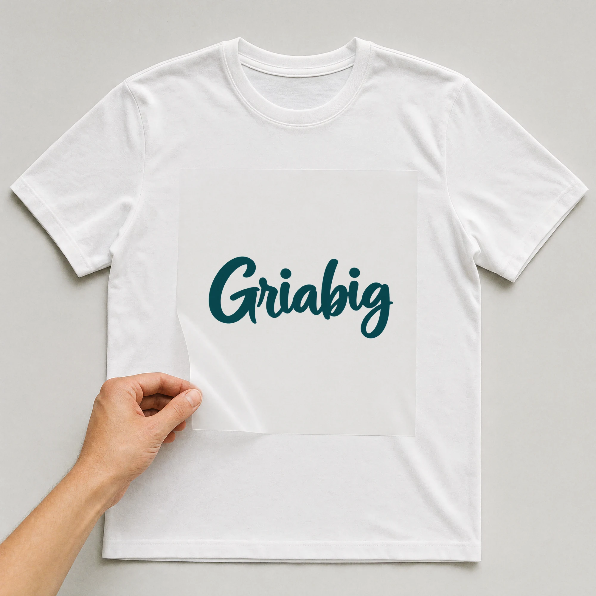 Bügelbild „Griabig“ auf weißem T-Shirt, Folie wird aufgelegt