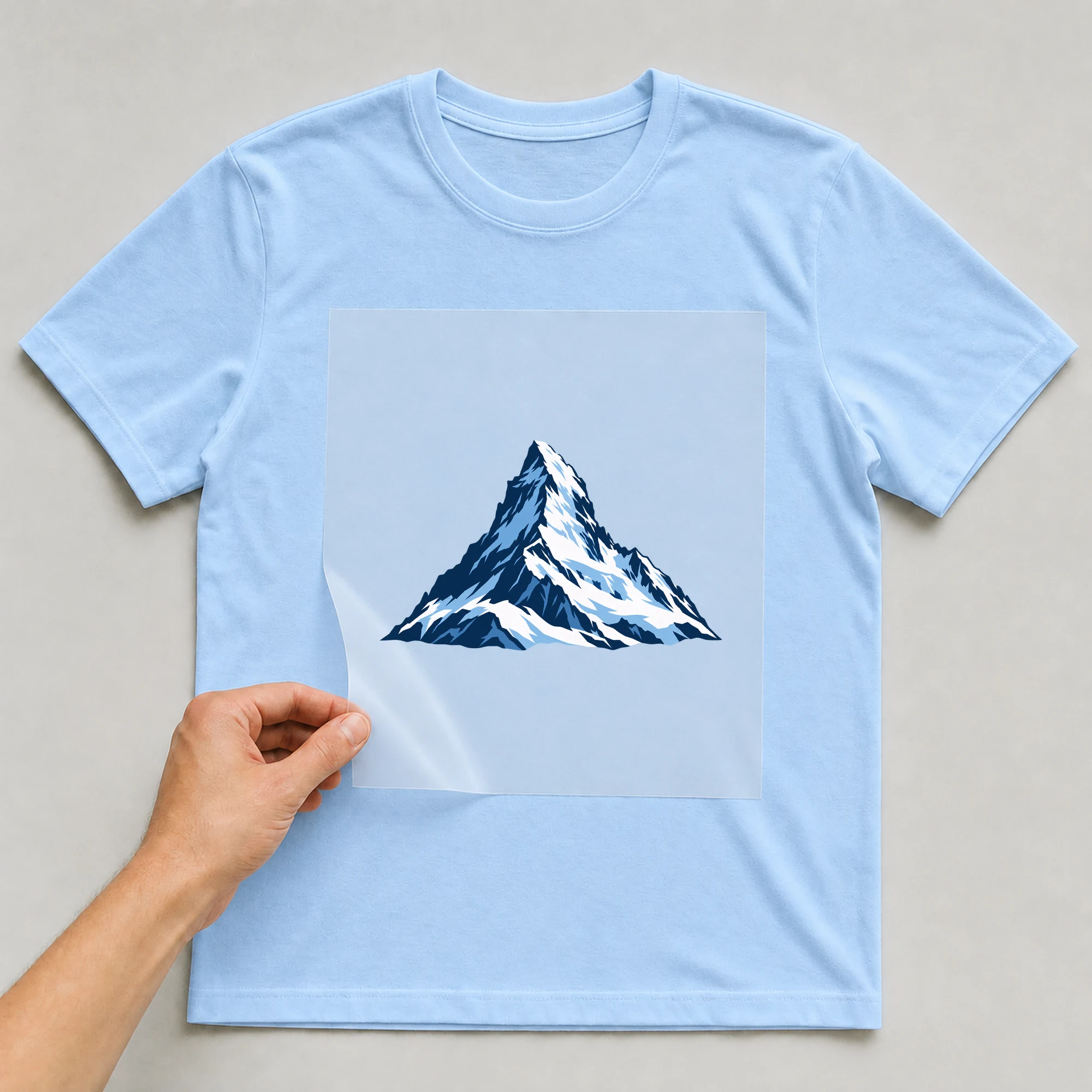 Bügelbild „Pop Art Matterhorn“ auf babyblauem T-Shirt, Folie wird aufgelegt