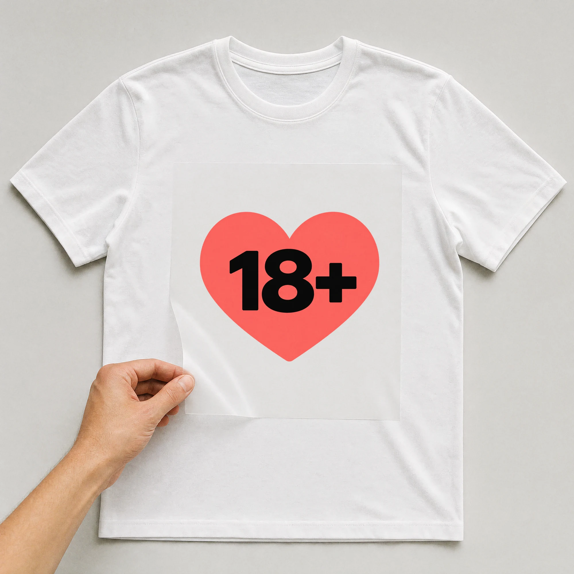 Bügelbild „18+“ auf weißem T-Shirt, Folie wird aufgelegt