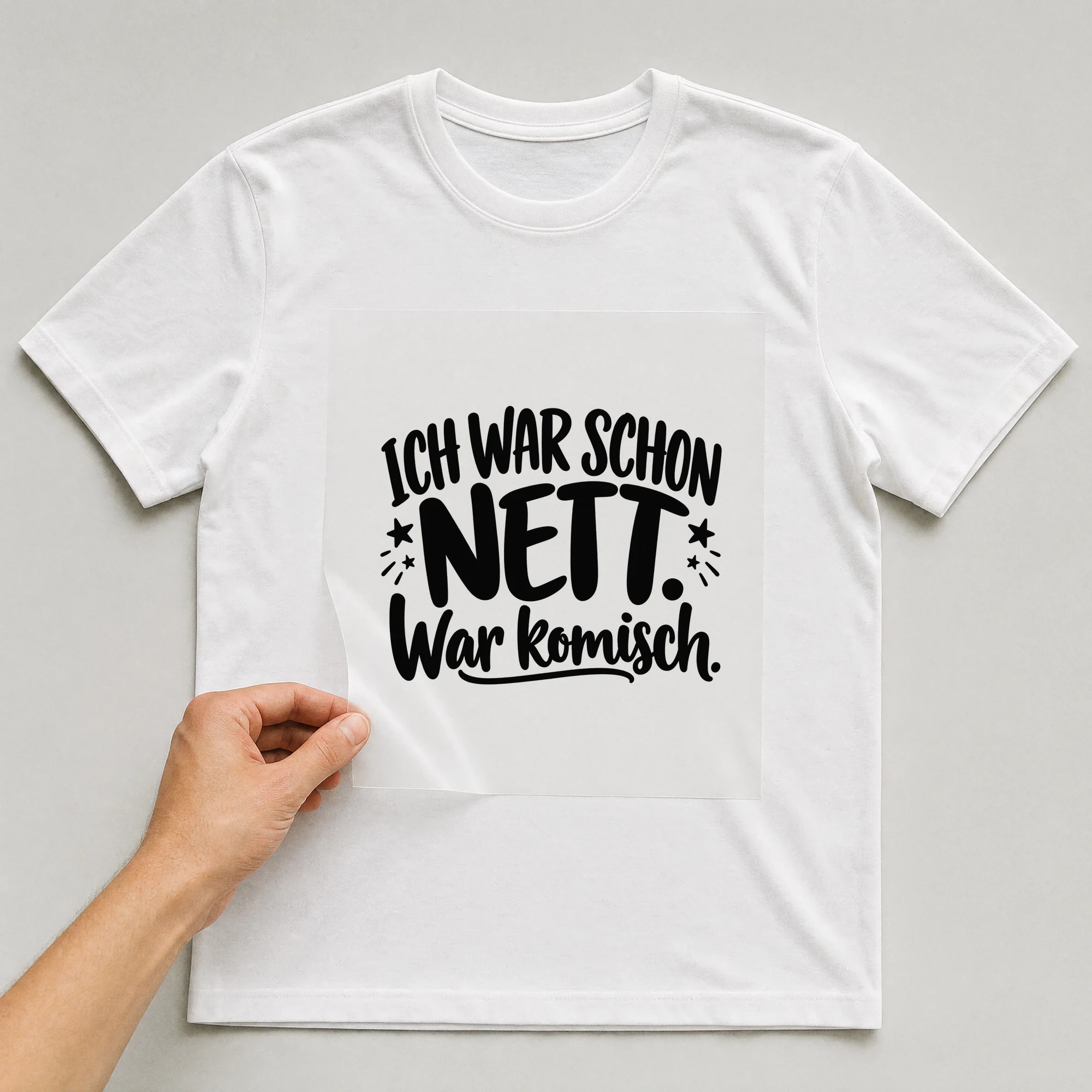 Bügelbild „Ich war schon nett. War komisch.“ auf weißem T-Shirt, Folie wird aufgelegt