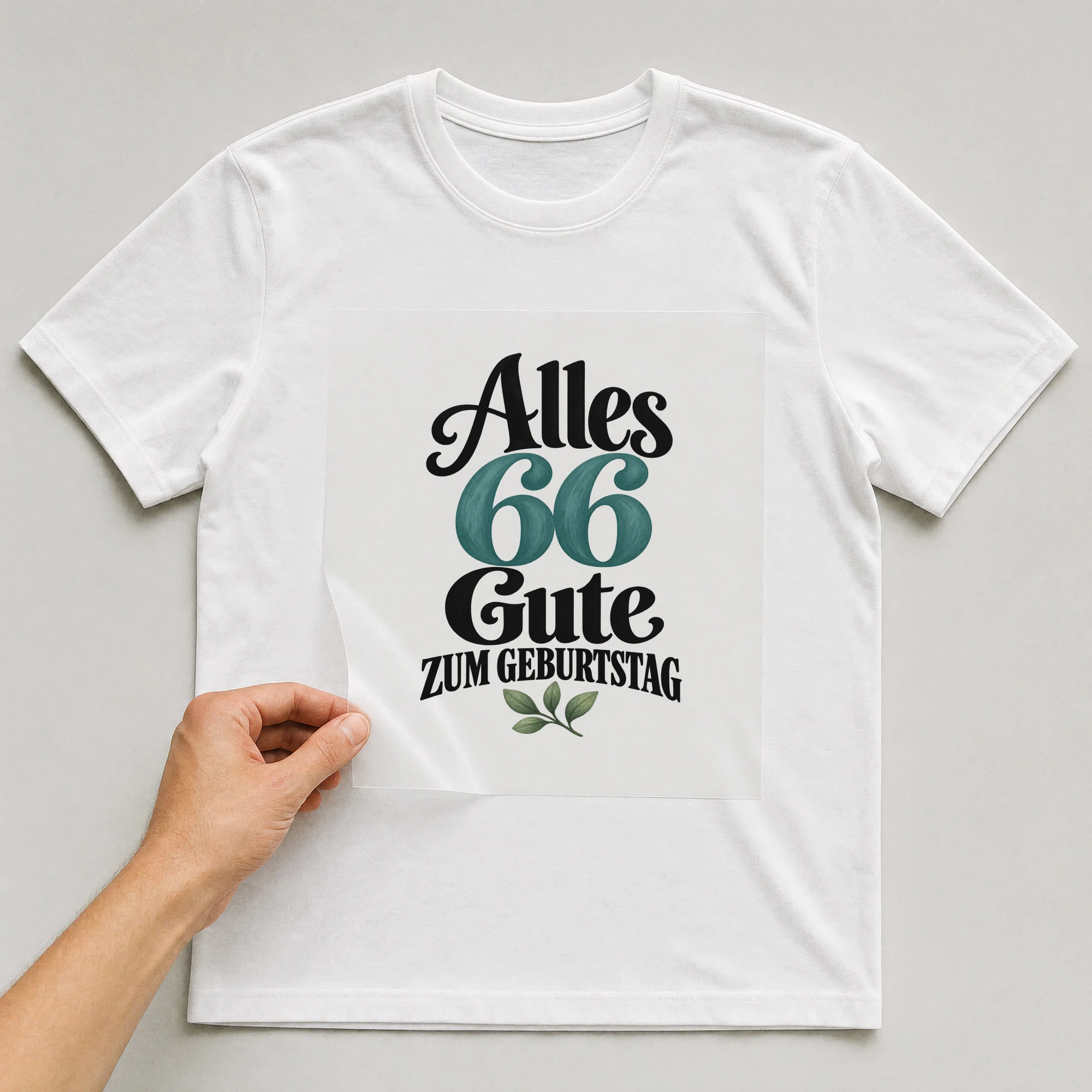 Bügelbild „Alles 66 Gute zum Geburtstag“ auf weißem T-Shirt, Folie wird aufgelegt