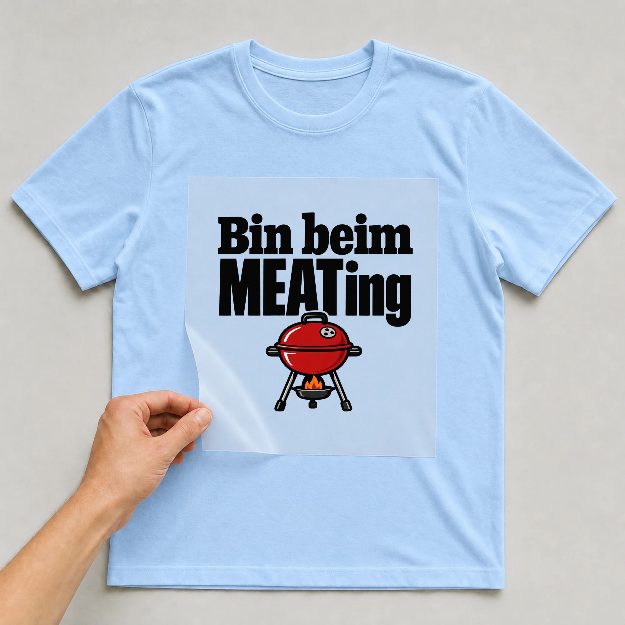 Bügelbild „Bin beim MEATing“ auf babyblauem T-Shirt, Folie wird aufgelegt