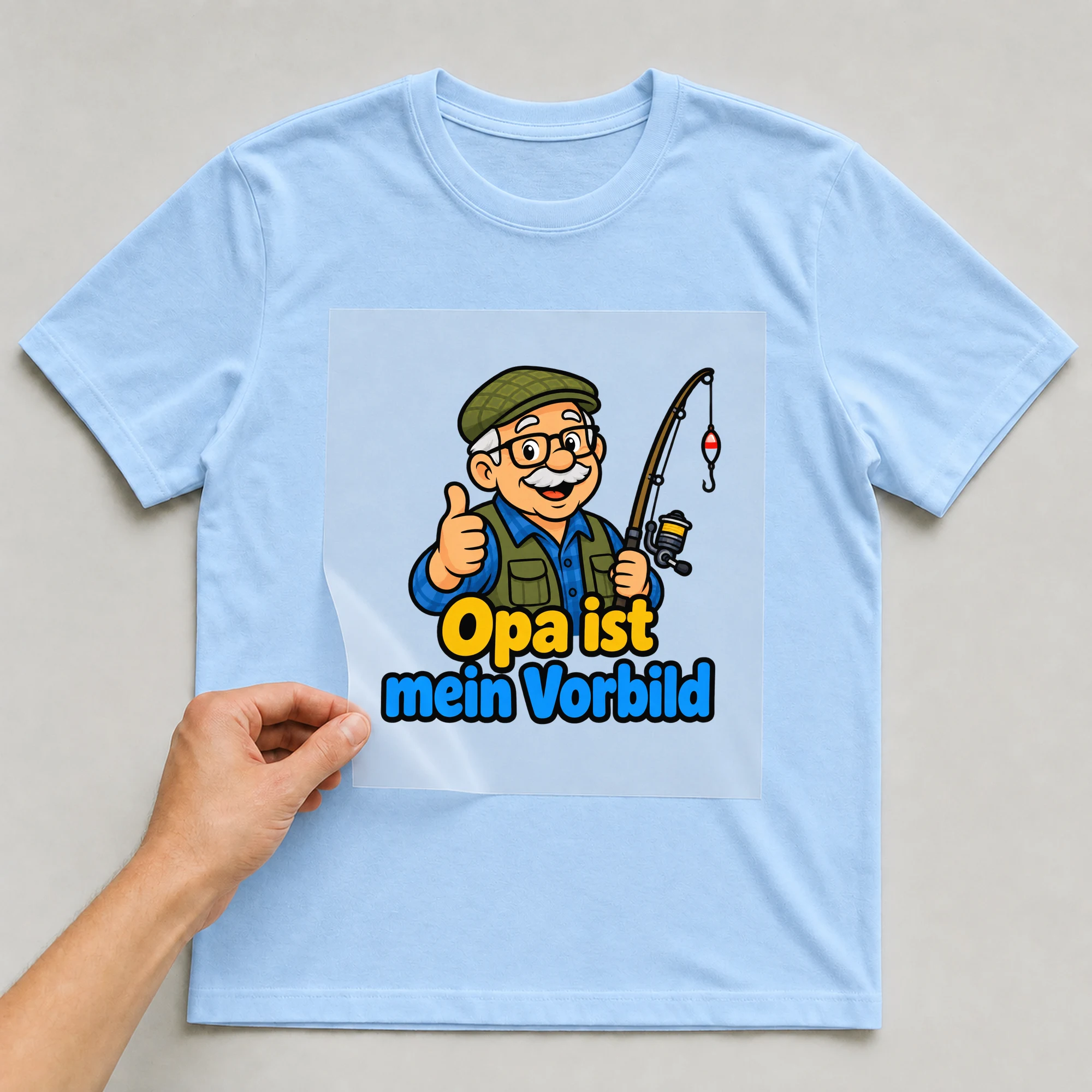 Bügelbild „Opa ist mein Vorbild“ auf babyblauem T-Shirt, Folie wird aufgelegt