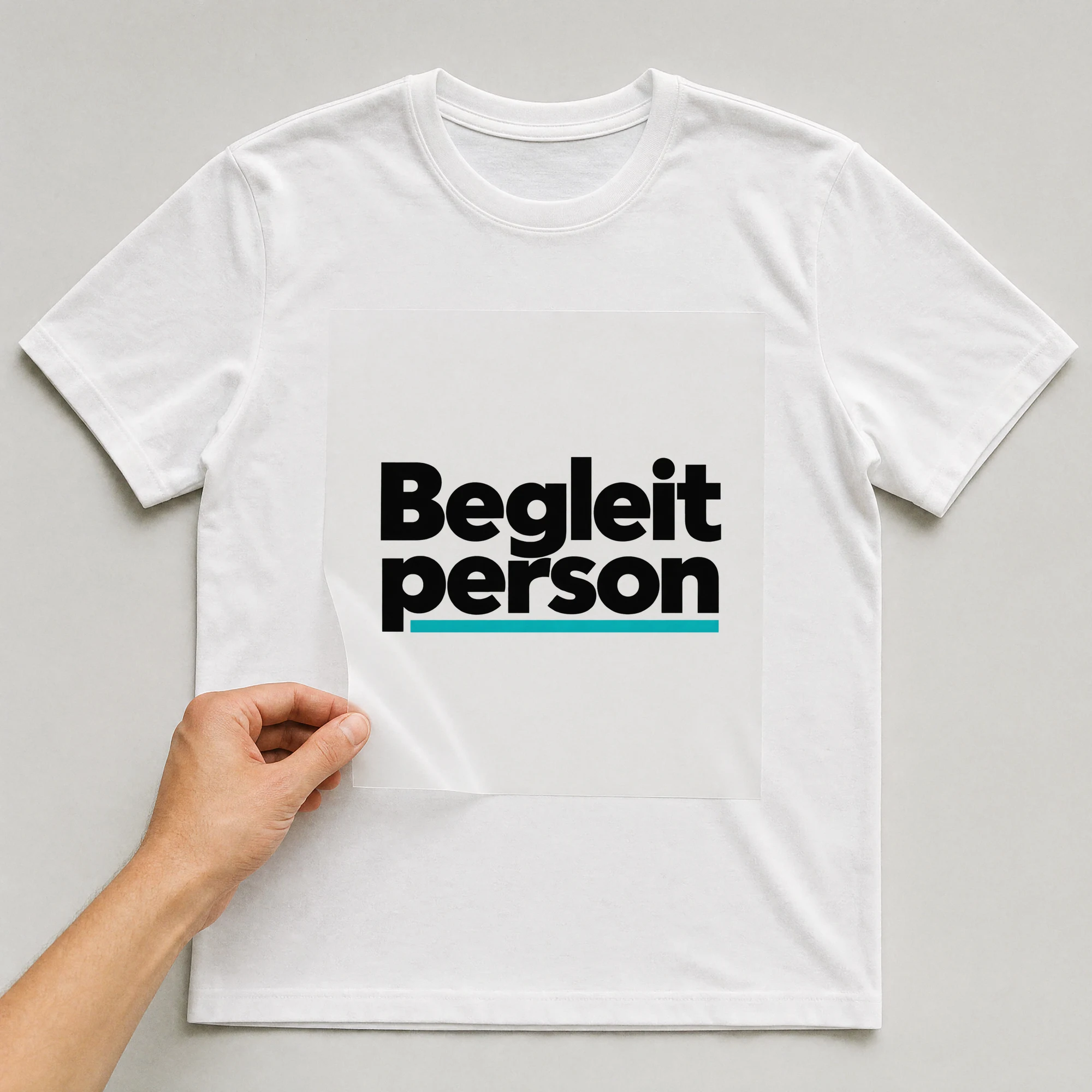 Bügelbild „Begleitperson“ auf weißem T-Shirt, Folie wird aufgelegt