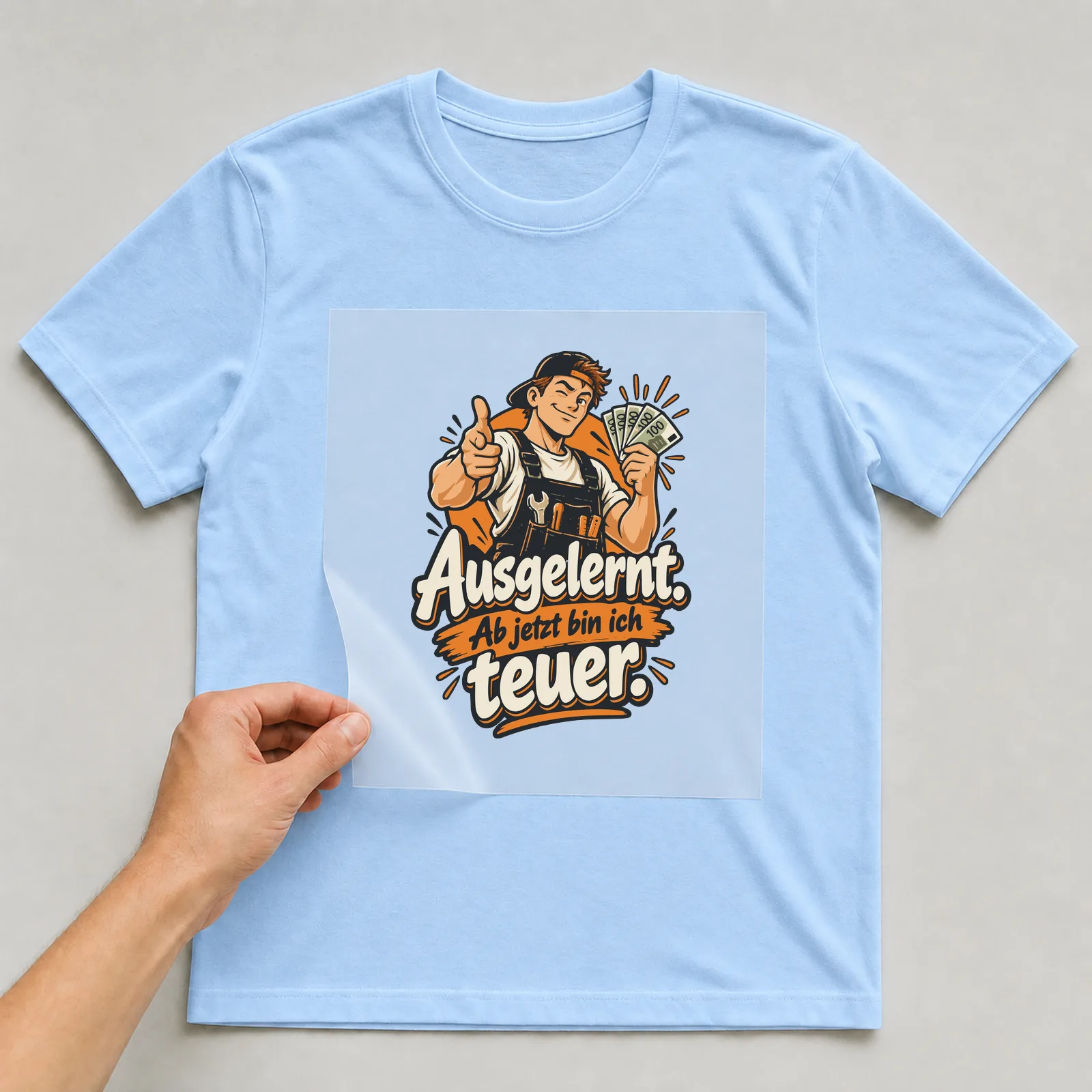 Bügelbild Ausgelernt. Ab jetzt bin ich teuer. auf hellblauem T-Shirt, Folie wird aufgelegt